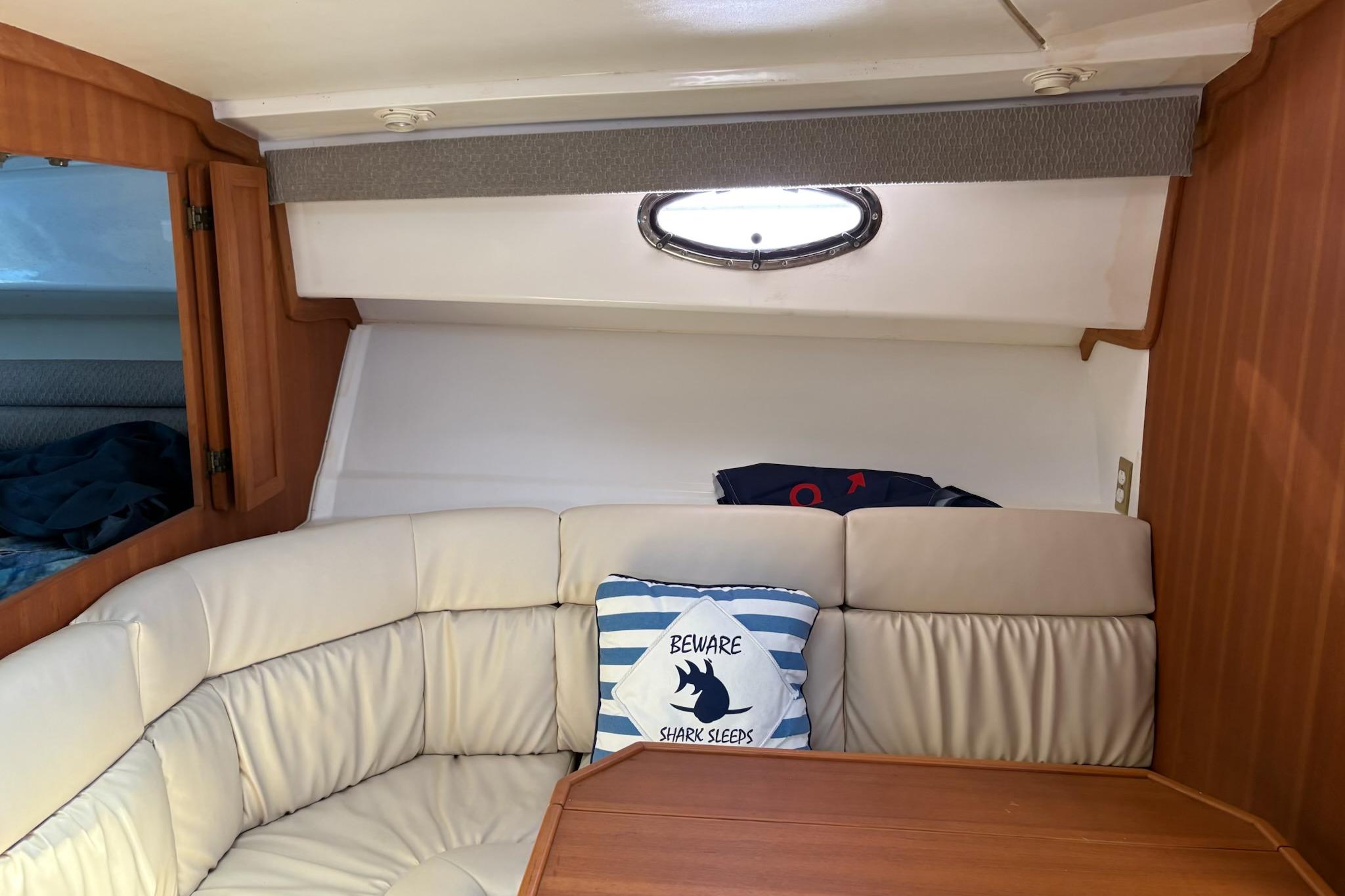Interior of 2008 Stamas 370 Express boat with cozy seating and nautical-themed pillow.