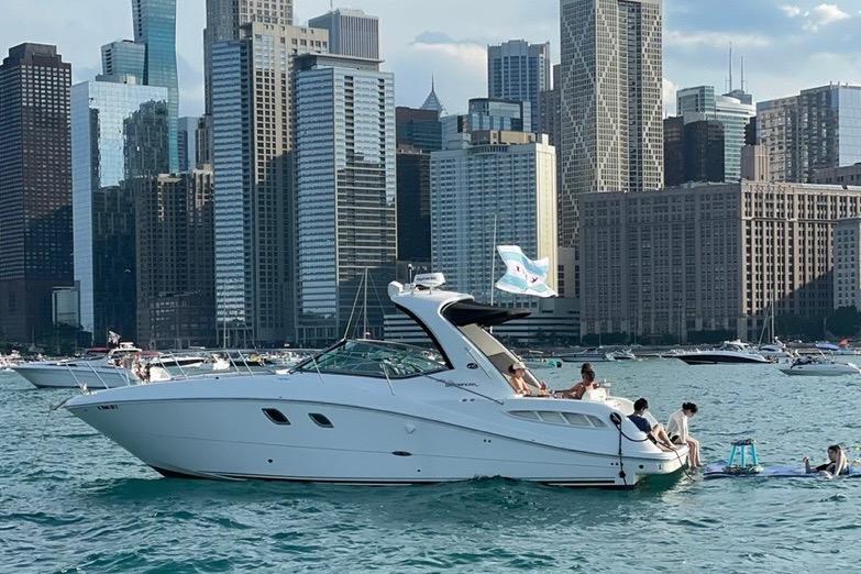 2008 Sea Ray 350 Sundancer yacht on water with city skyline backdrop.