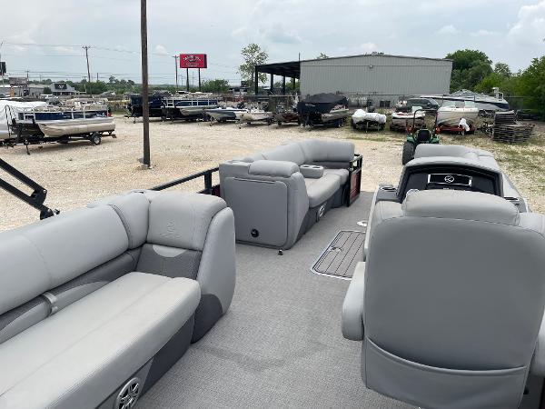 2023 Regency 250DL3 pontoon boat with spacious seating in a boatyard setting.