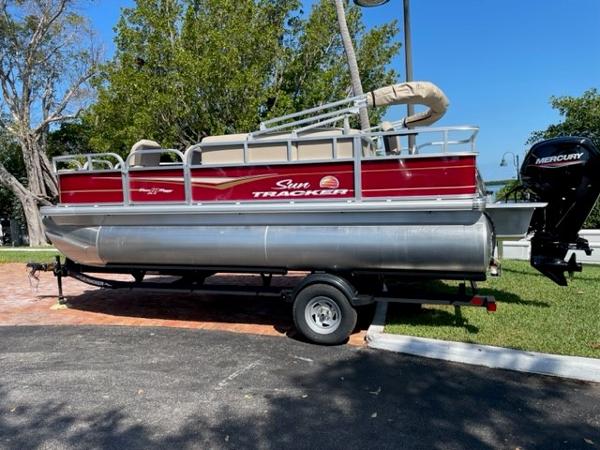 2024 Sun Tracker Bass Buggy 18 DLX pontoon boat on trailer, side view.