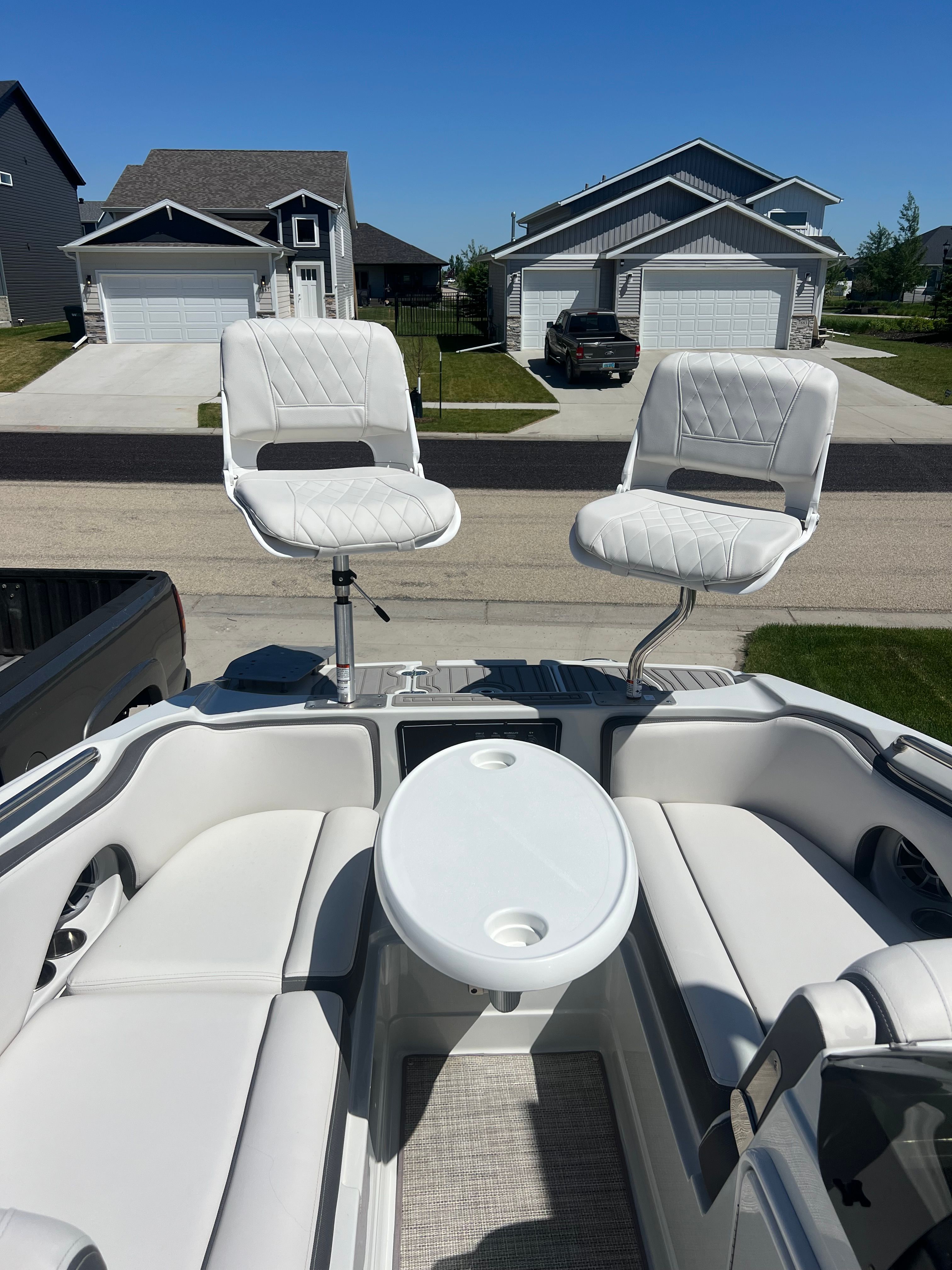 2024 Crownline Eclipse E210 XS boat with white seats and table.