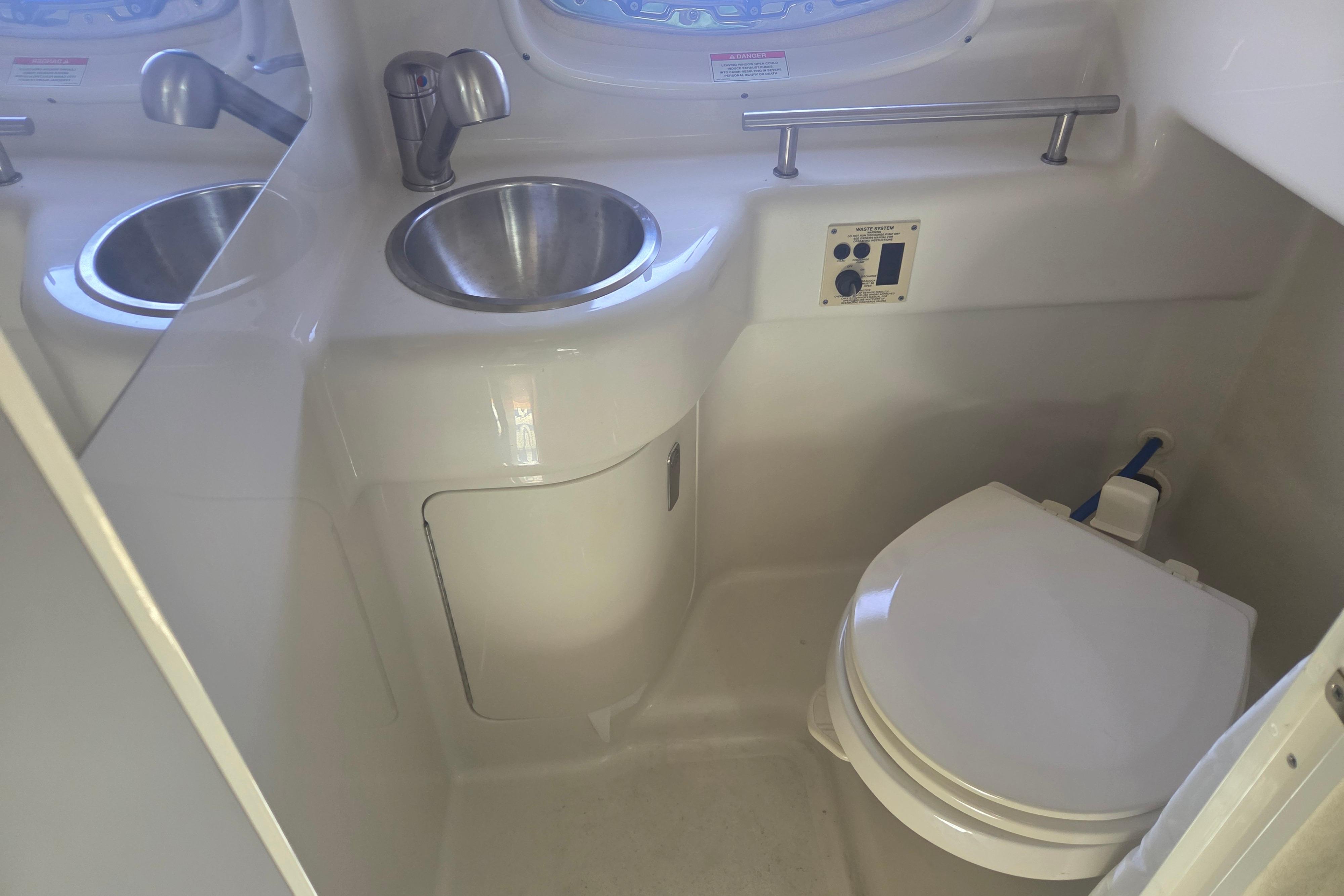 Interior of 2012 Sea Ray Sundancer 260 boat bathroom with sink and toilet.