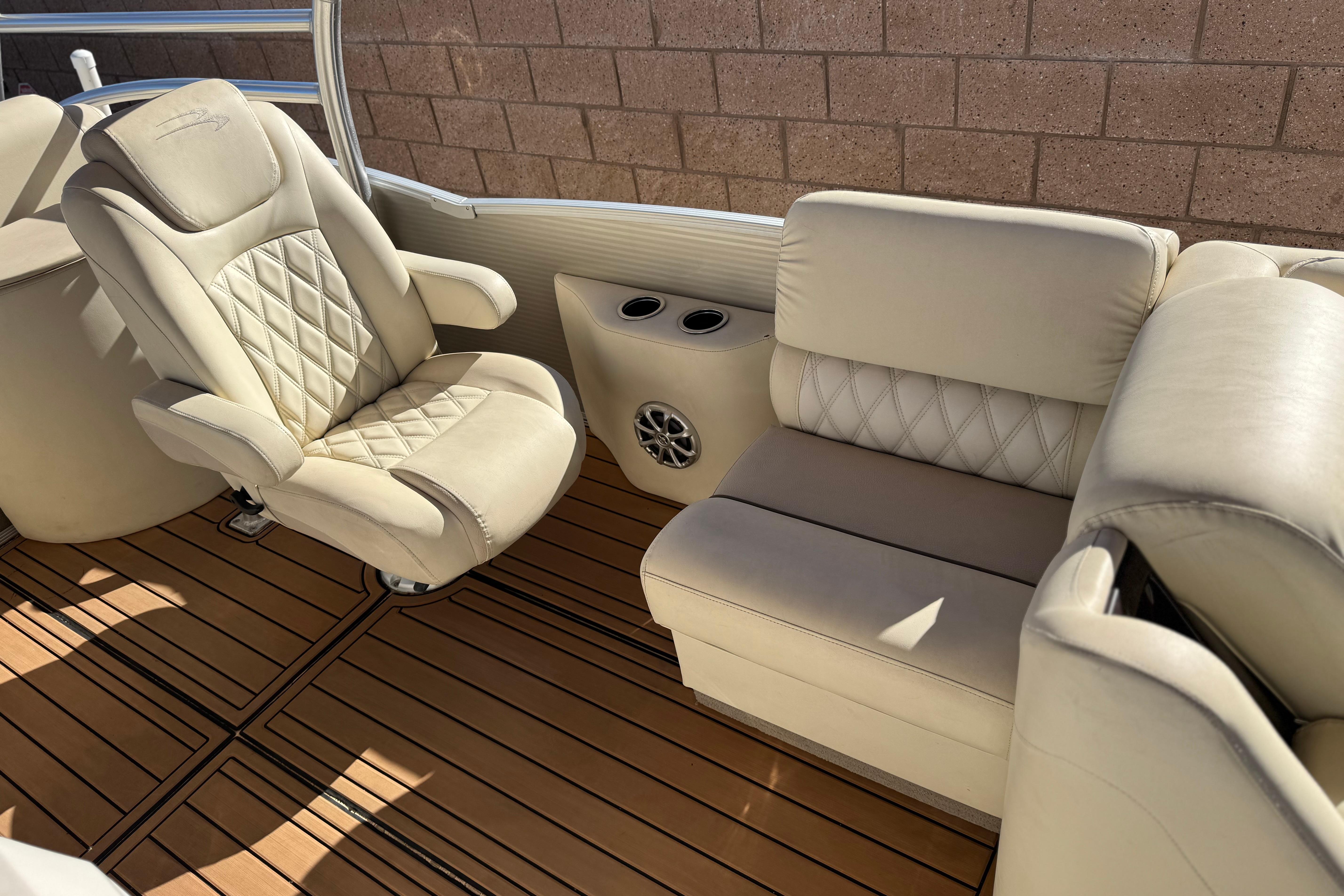 Luxurious interior of 2013 Bennington 2575QCW I/O boat with plush seating and wood flooring.