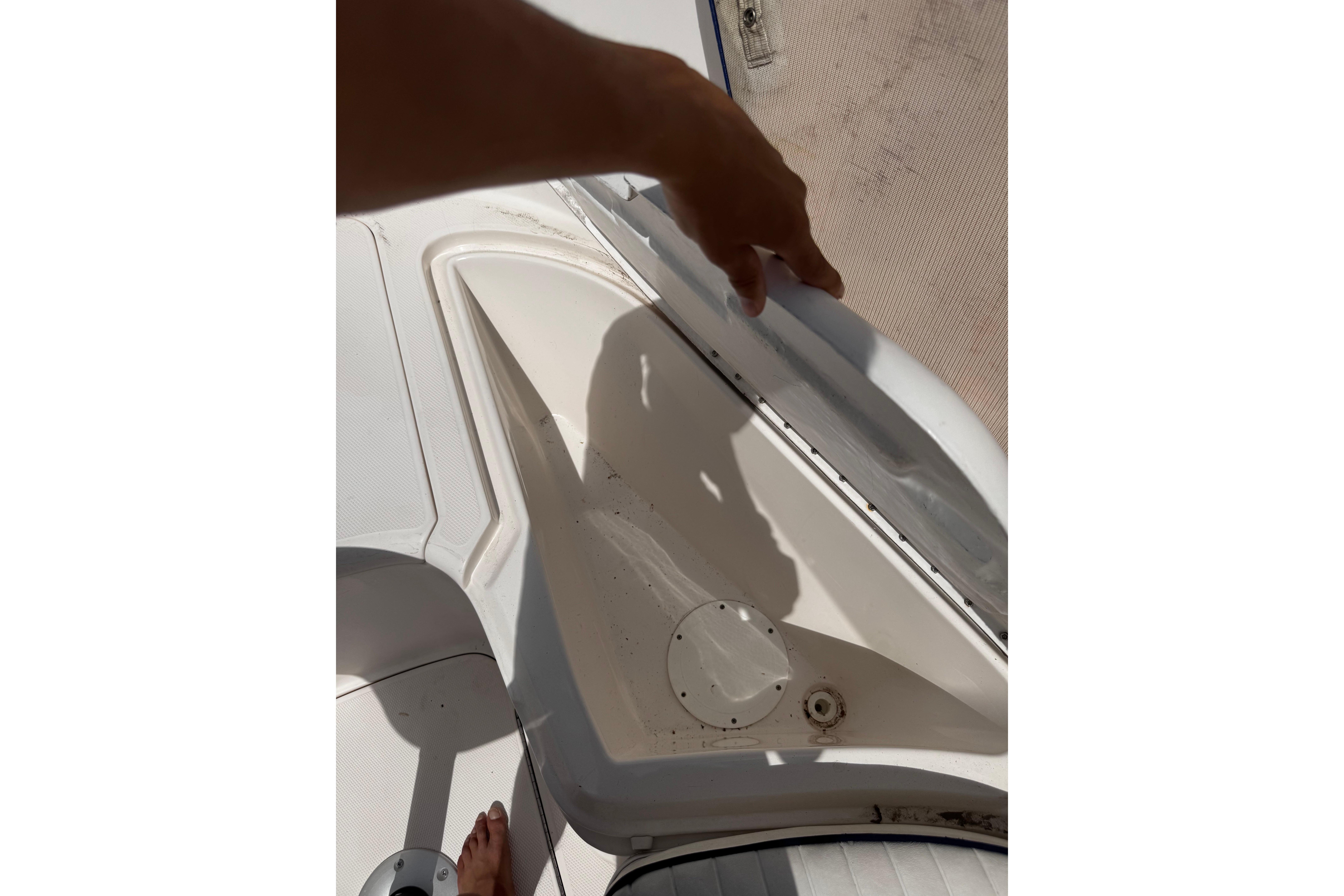 2003 Palm Beach 2200 Dual Console boat storage compartment being opened.