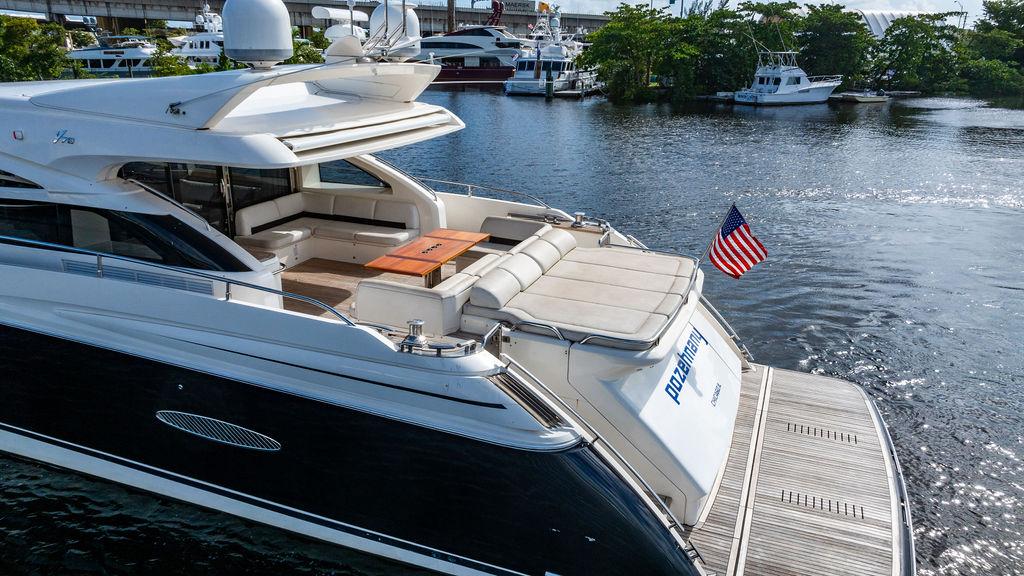 Luxury 2010 Princess V78 yacht docked, featuring spacious deck and American flag.