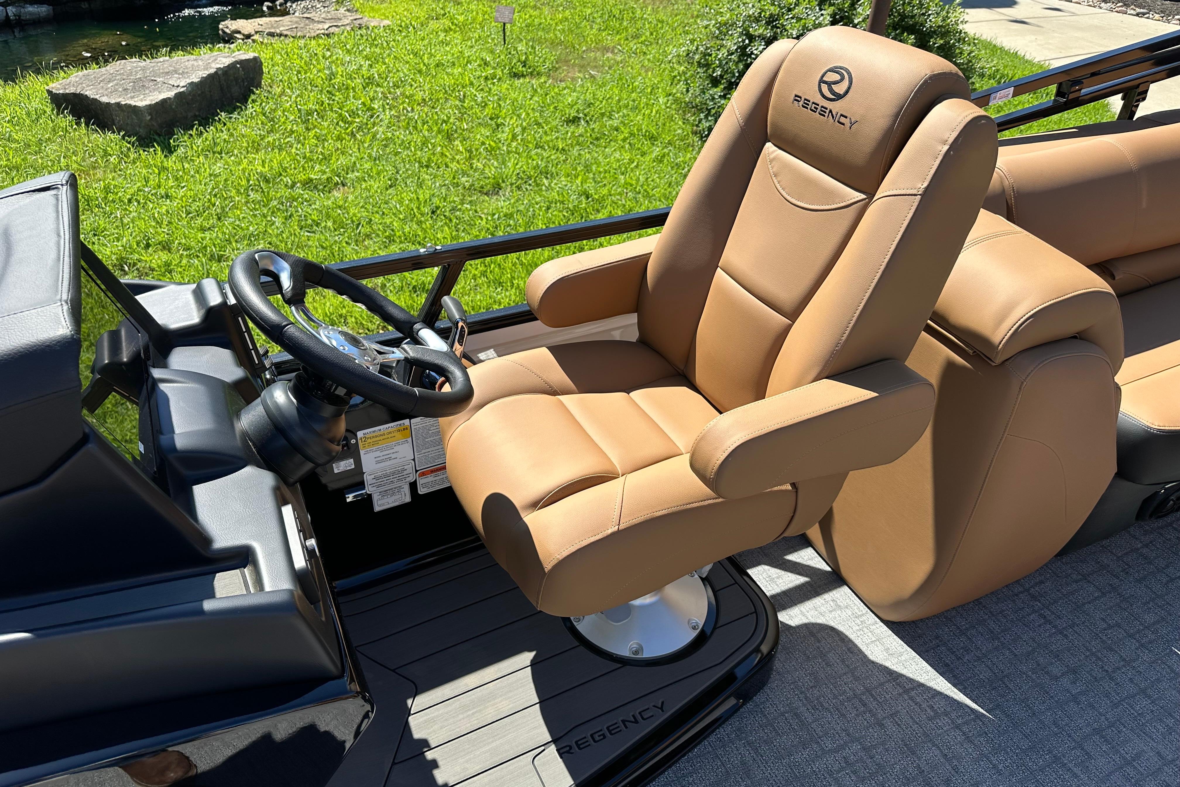 Luxurious captain's chair on 2026 Regency 230 DL boat, featuring tan upholstery and sleek design.