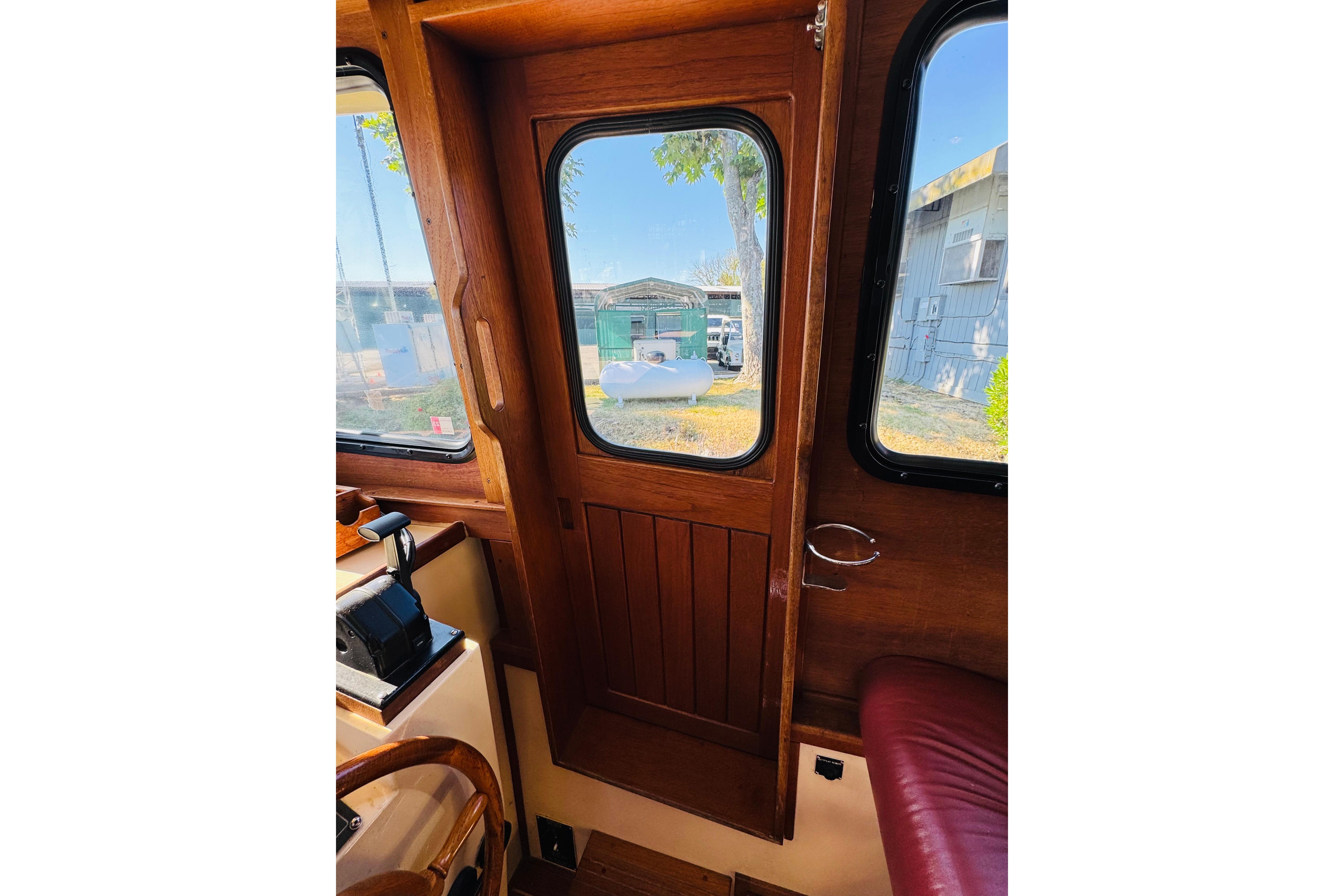 Interior view of a 1996 Nordic Tug 32, featuring wooden door and windows.