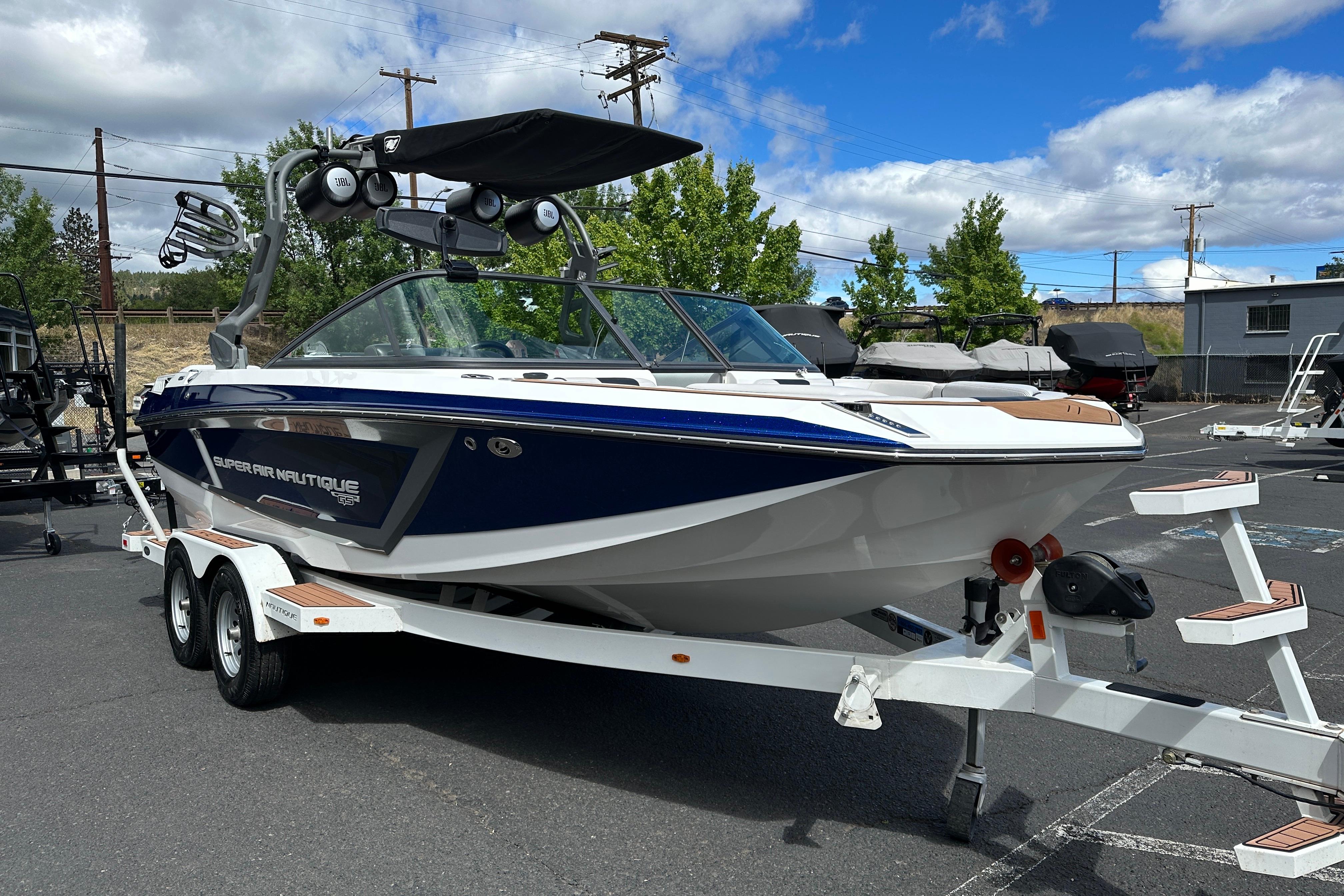 2017 Nautique Super Air Nautique GS20 boat on trailer, parked outdoors under cloudy sky.