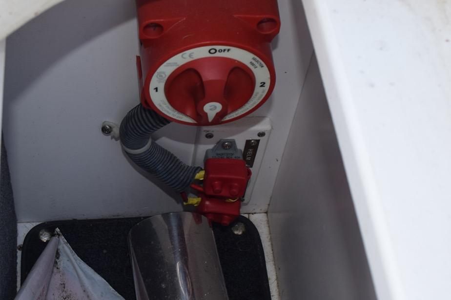 Red battery switch in a 2006 Cobalt 240 boat compartment.