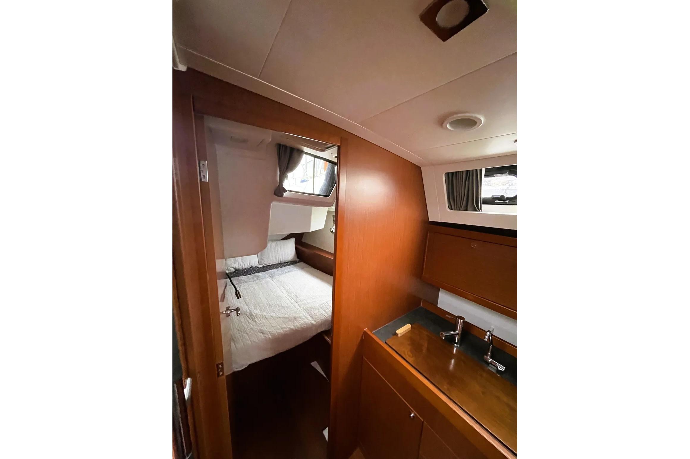 2018 Beneteau Oceanis 45 interior cabin with bed and wooden cabinetry.