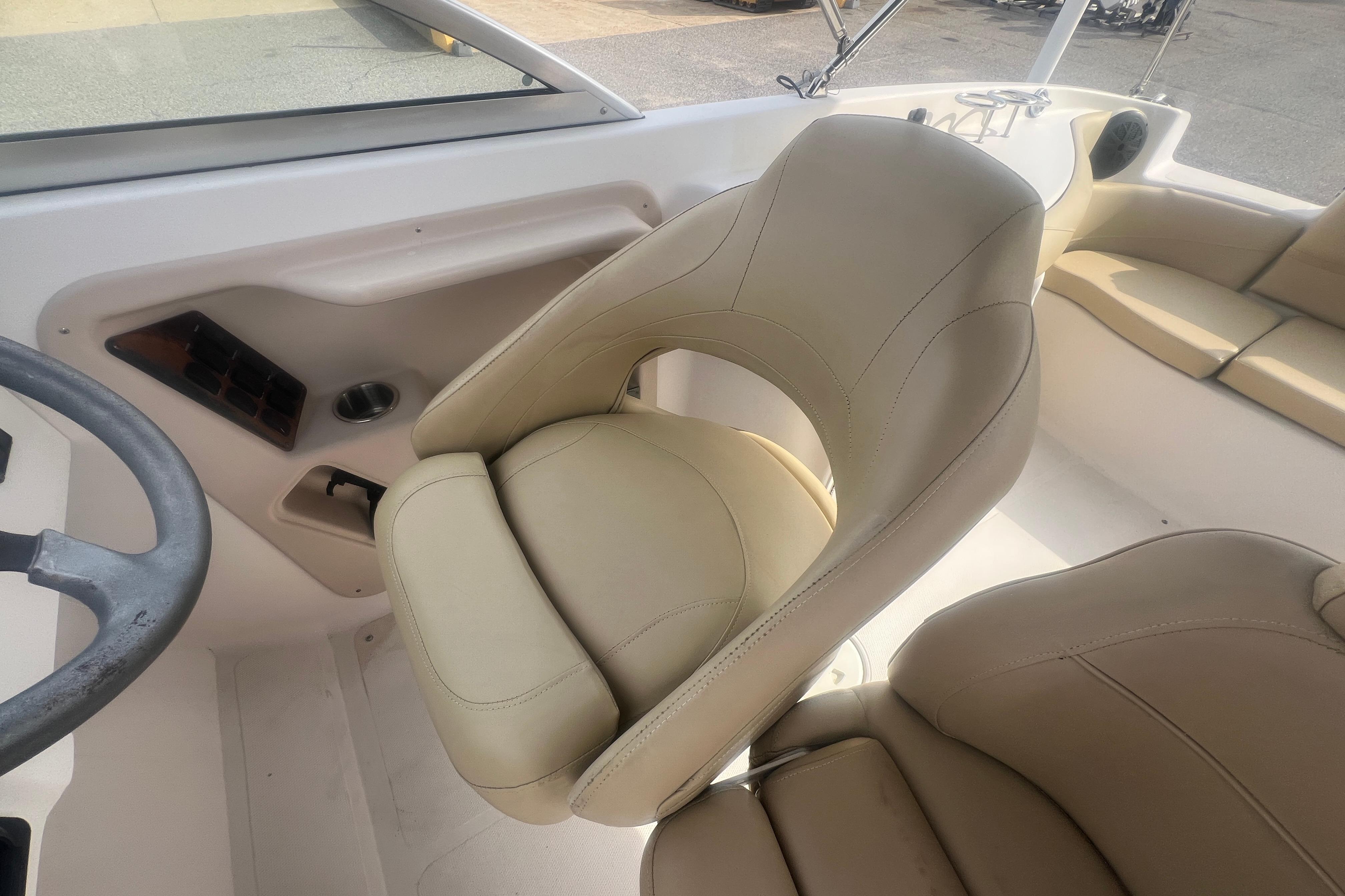 2002 Hurricane SunDeck 260 OB boat interior with beige seating and steering wheel.