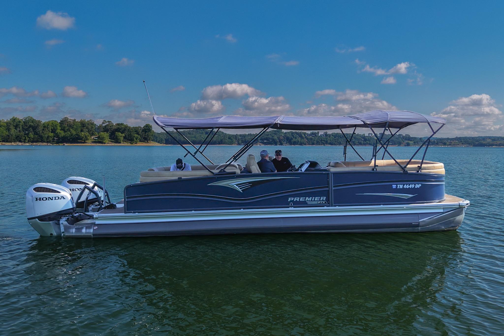 2023 Premier 270 Intrigue RF pontoon boat on a serene lake.