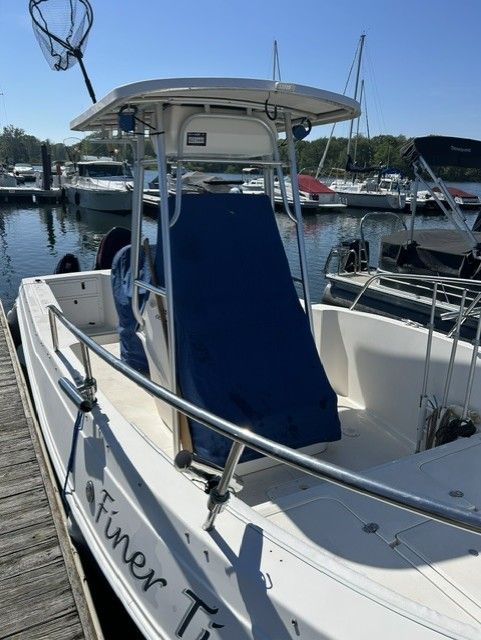A 2000 Aquasport Osprey 250 boat docked. It features a blue T-top.