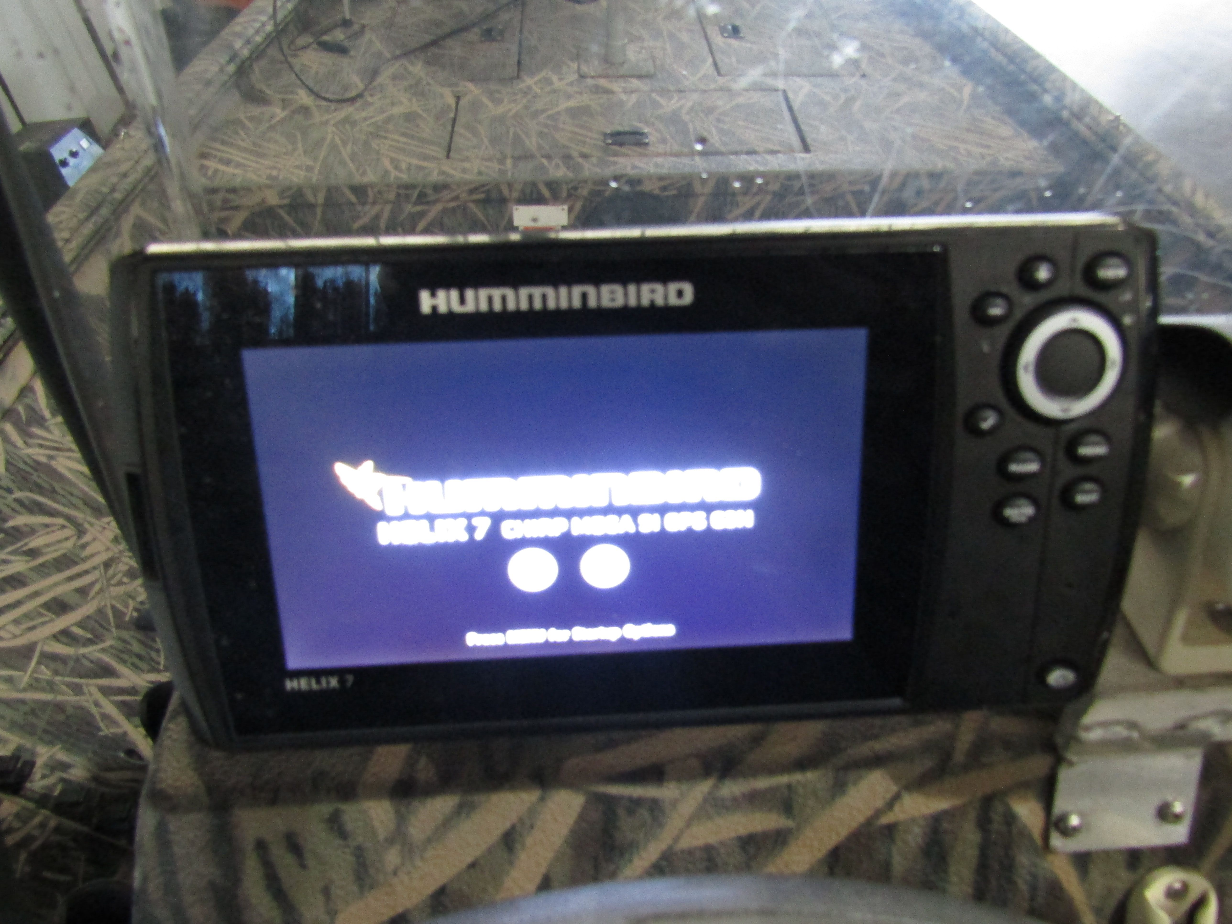 A Humminbird Helix 7 fish finder on a camouflaged boat.