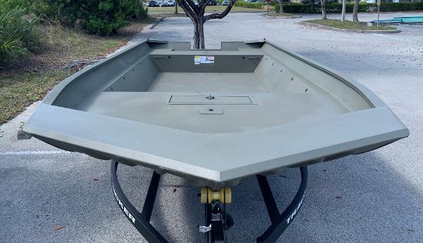 2025 Tracker GRIZZLY 2072 Utility boat on trailer in parking lot.