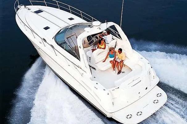 2000 Sea Ray 380 Sundancer cruising with passengers on a sunny day.