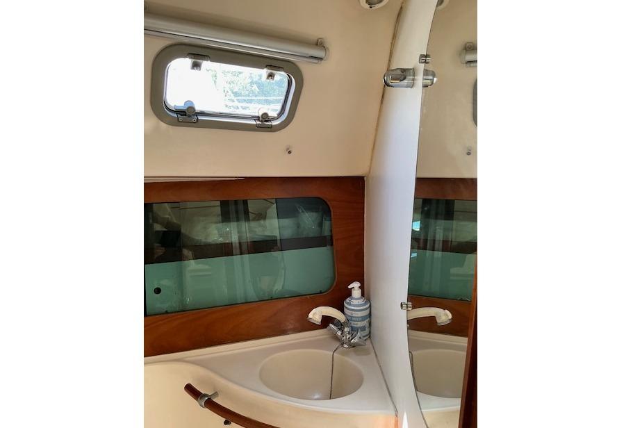 Interior of 2000 Beneteau Oceanis 321 yacht bathroom with sink and window.