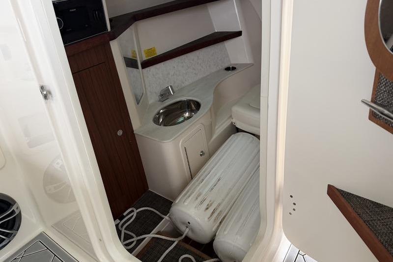 Interior of 2025 Grady-White Freedom 325 boat, featuring a compact sink and storage area.