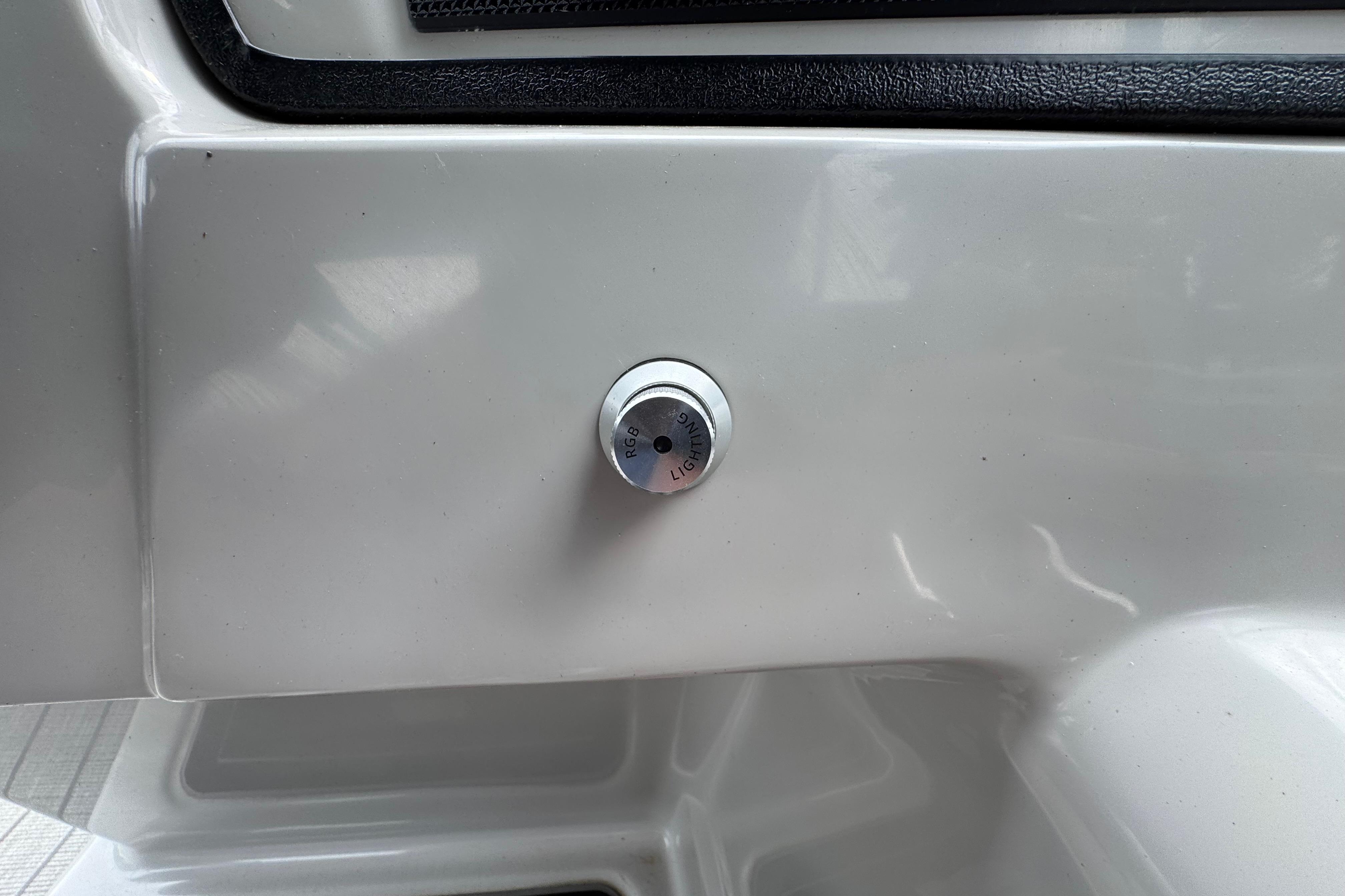 2023 Starcraft MX 25 DL DH boat detail, featuring a control knob on a sleek white panel.