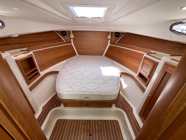 2024 Back Cove 34O cabin with wood paneling, bed, and skylight.