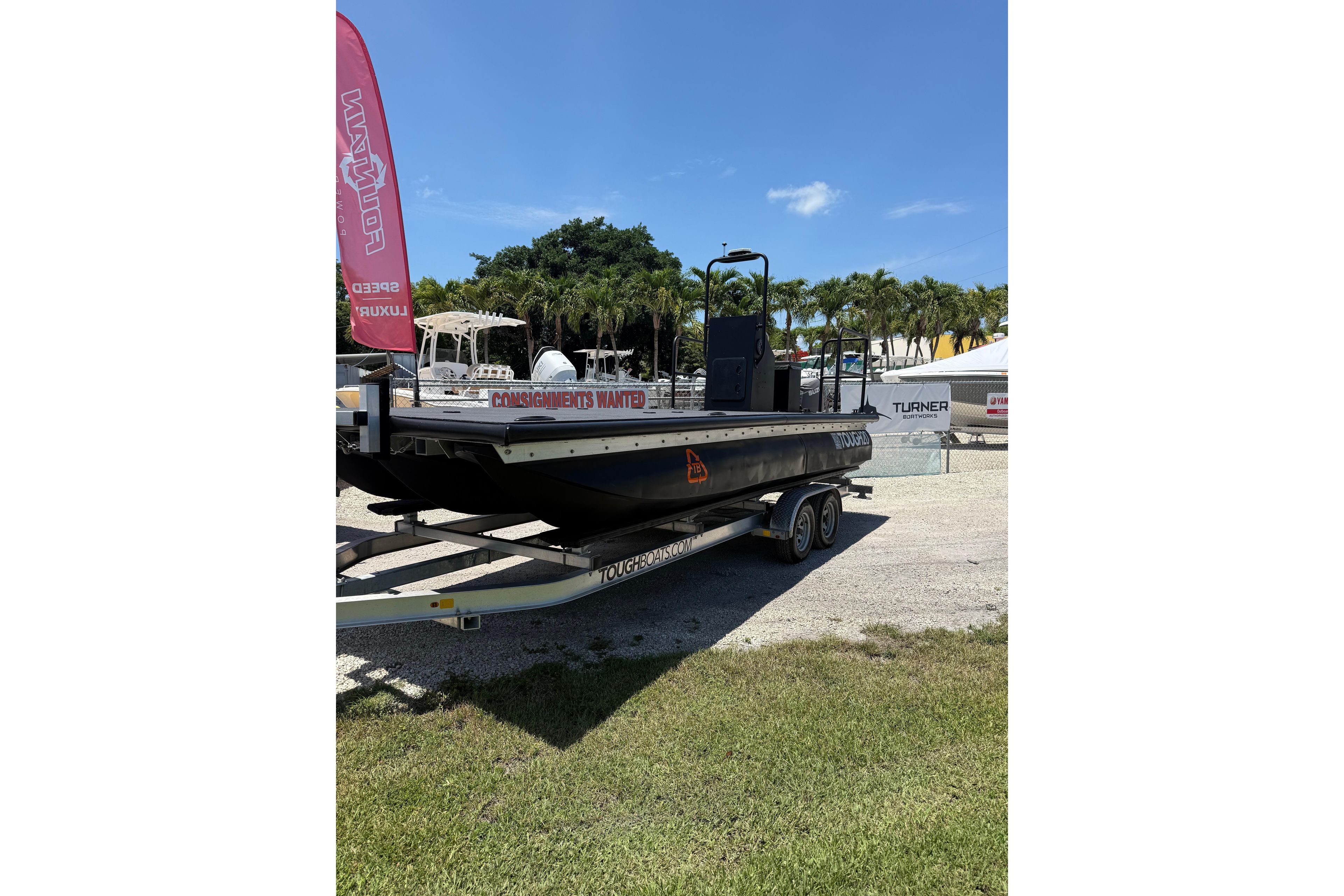 Trailer-mounted Tough 20 boat, 2026 model, displayed outdoors with palm trees in the background.