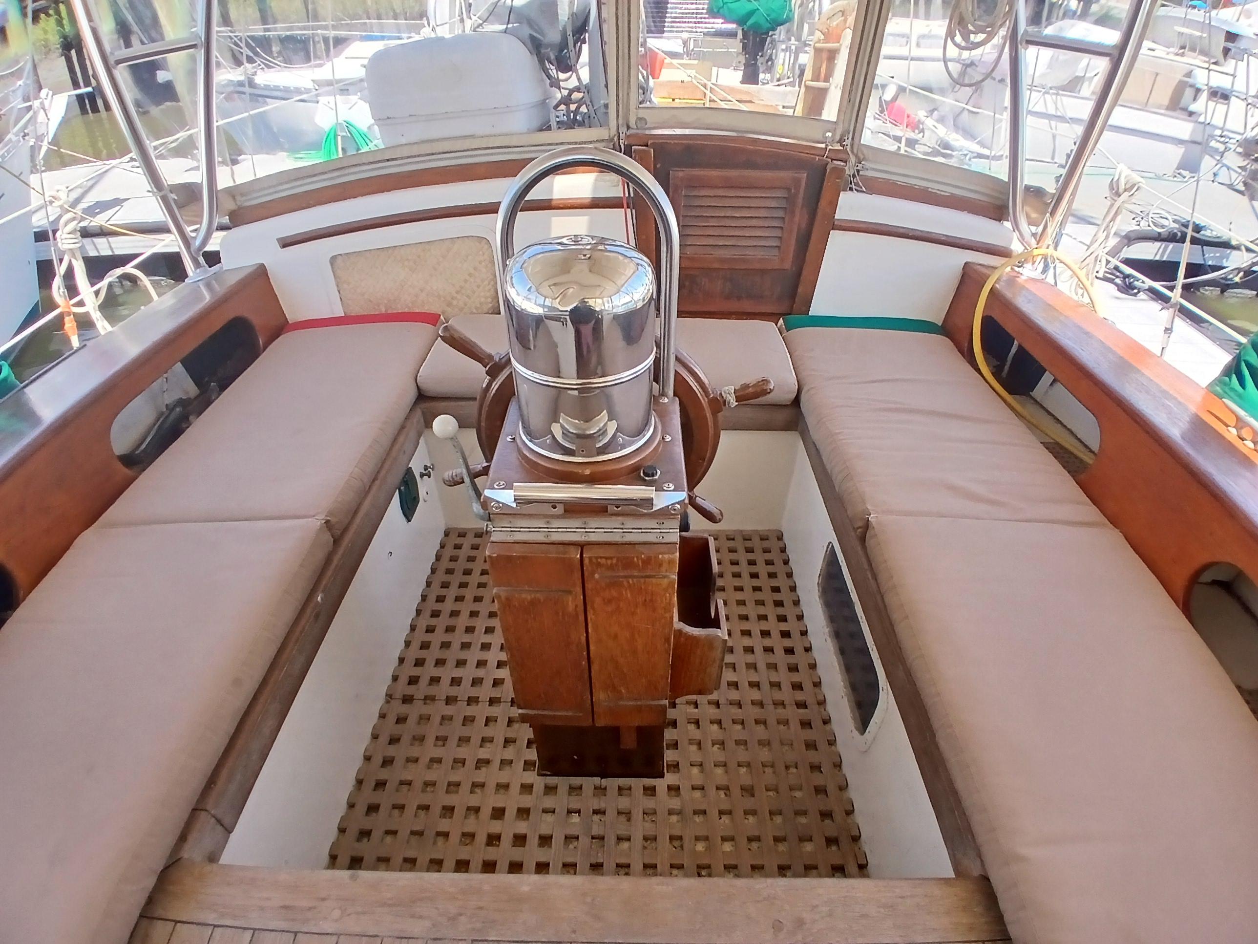 Cockpit of 1977 Dickerson 41 sailboat with wooden seating and steering wheel.