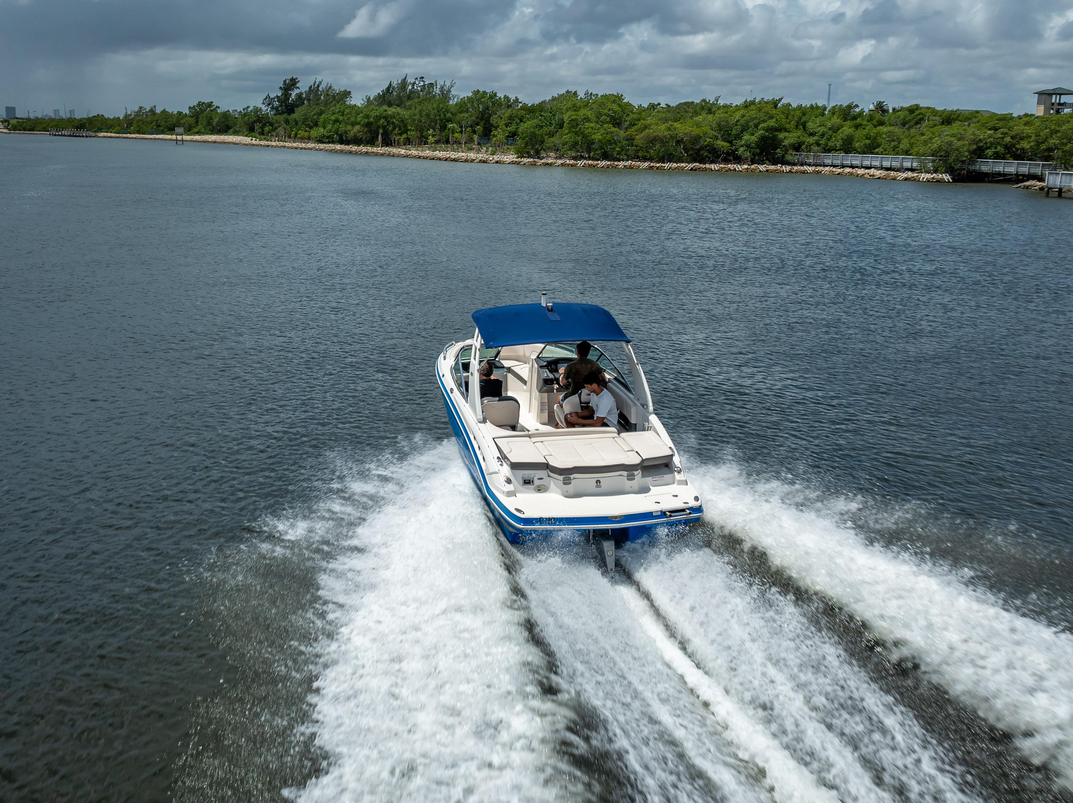 2017 Chaparral 227 SSX boat cruising on a scenic waterway under cloudy skies.