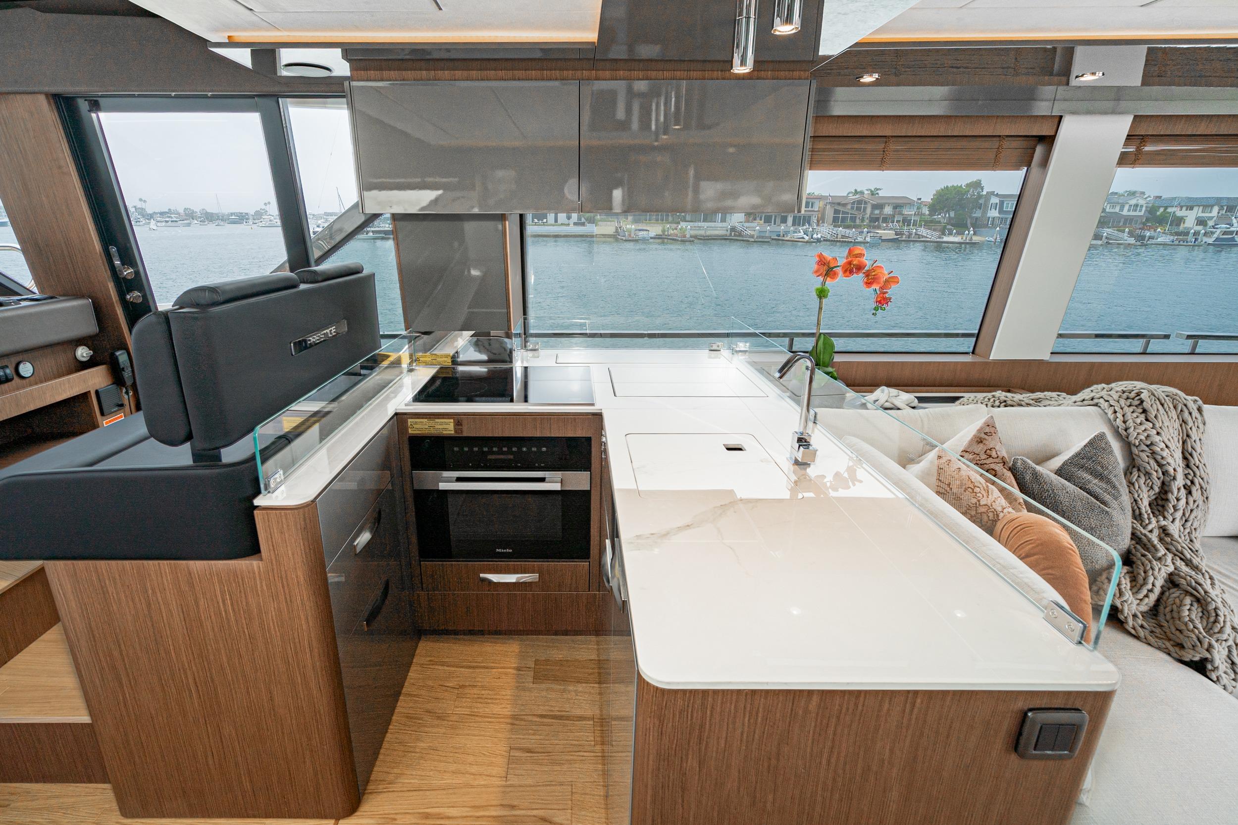 Luxurious 2024 Prestige X60 yacht interior with modern kitchen and waterfront view.
