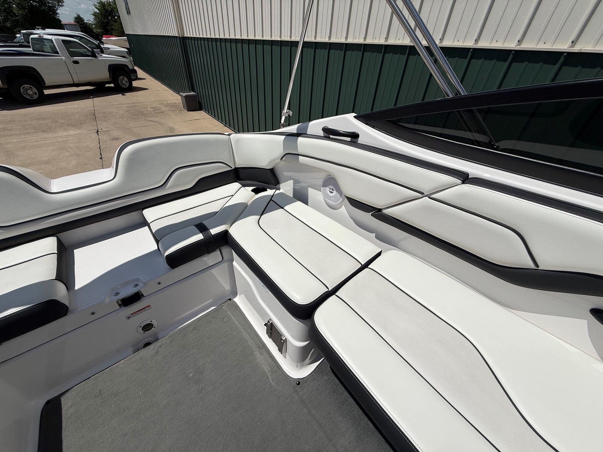 Interior view of a white Yamaha SX210 boat with black accents, parked on land.