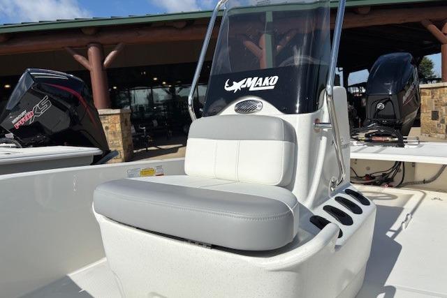 2026 Mako Pro Skiff 15 CC boat with seating and console, displayed outdoors.