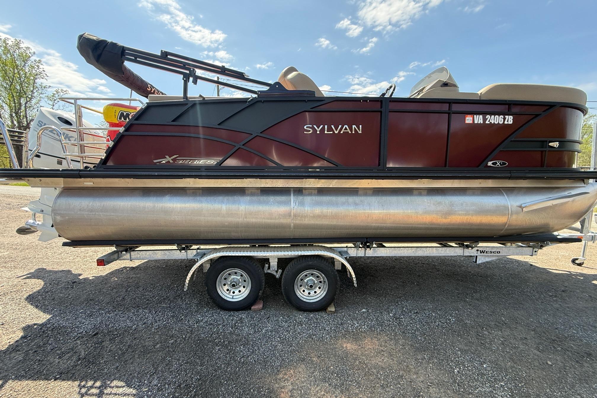 2024 Sylvan X1 CLZ DH pontoon boat on trailer, side view under clear sky.
