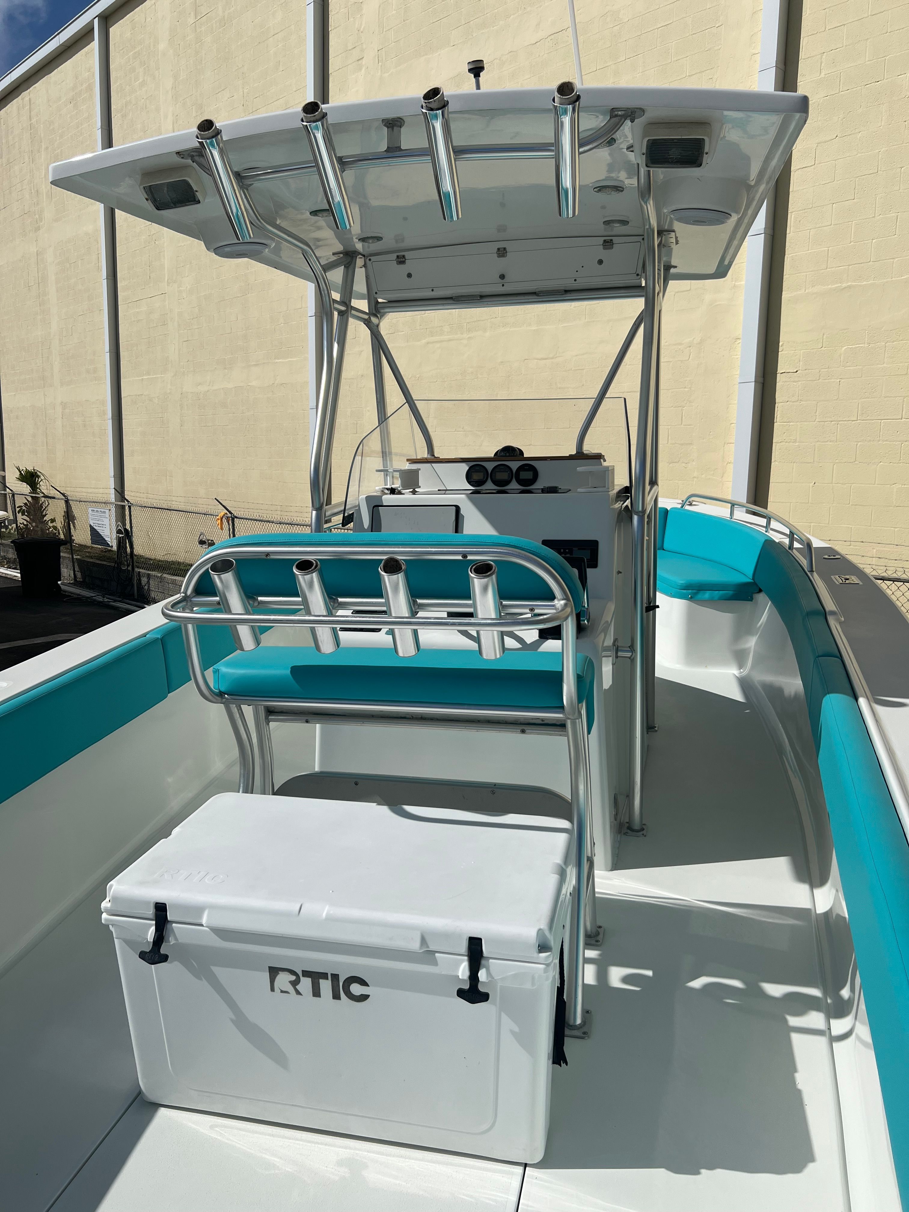 A 2008 Custom 28 Center Console boat with turquoise seating and a white RTIC cooler.