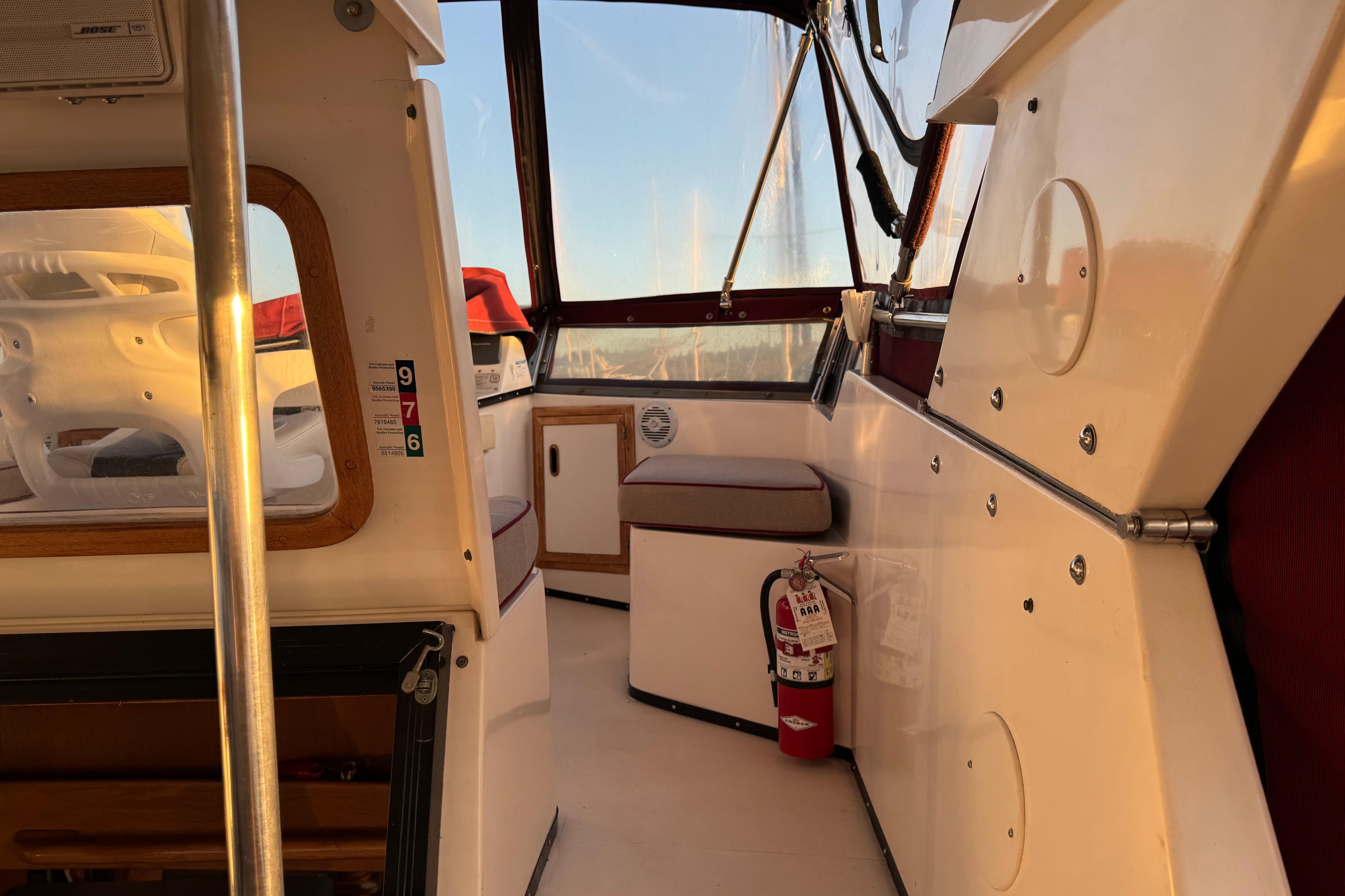 Interior of a 1987 President 37 boat with seating and a fire extinguisher.