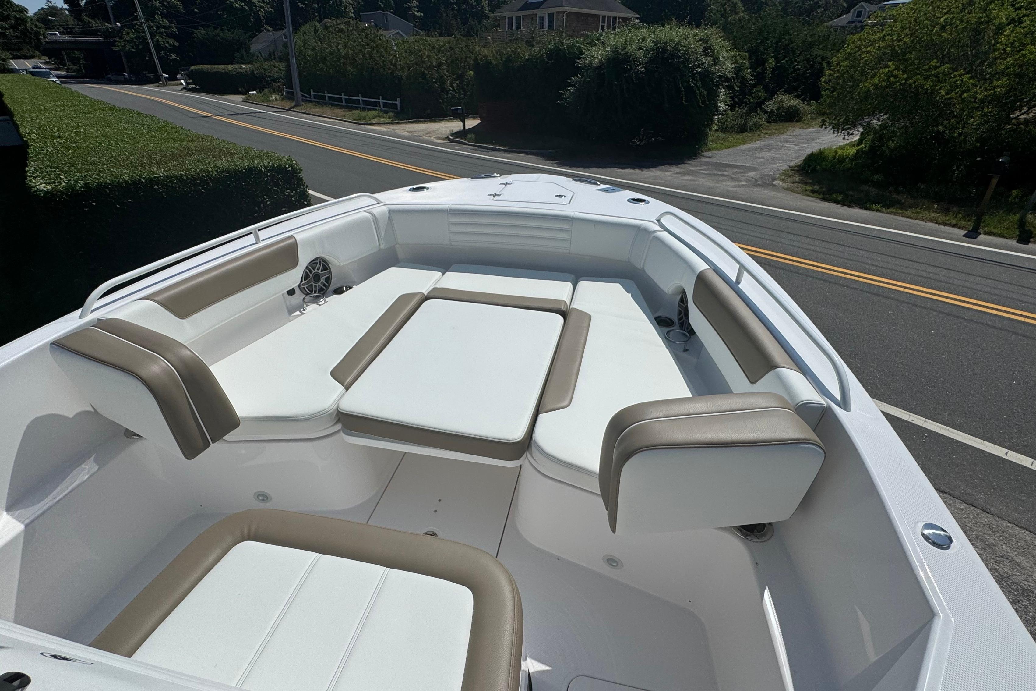 2026 Edgewater 250CC boat interior with cushioned seating, parked near a road.