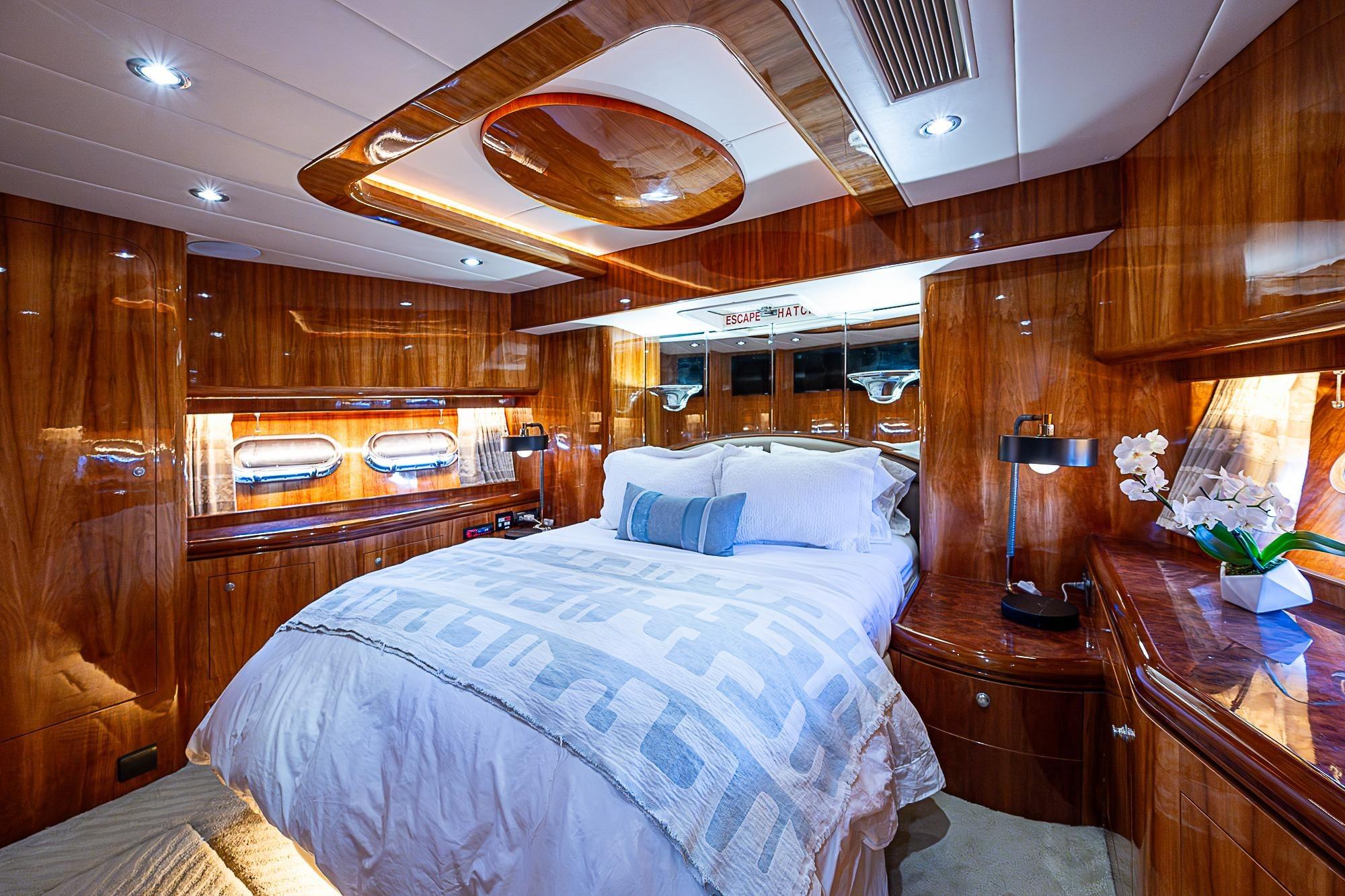 Luxurious cabin interior of 2000 Horizon 82 yacht with elegant wood finish and cozy bedding.