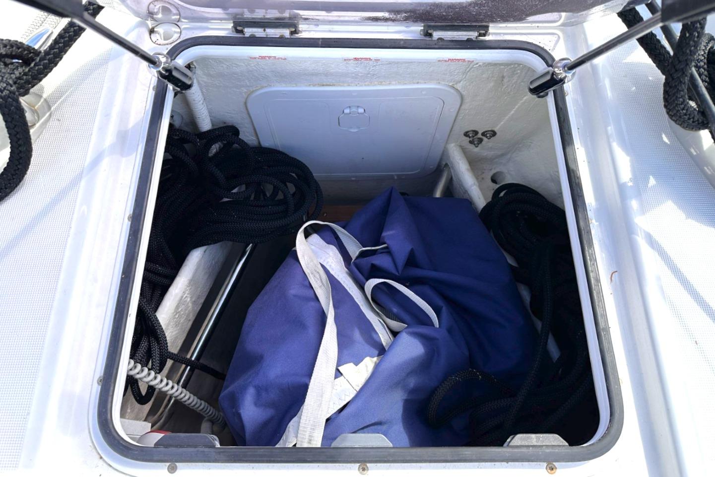 Open storage compartment on 2021 Wauquiez Pilot Saloon 48 yacht with ropes and blue bag.