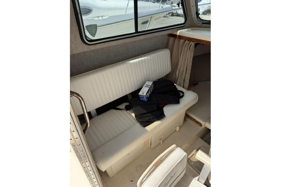 Interior of a 2006 Parker 2520 SL Sport Cabin with white seating and window view.