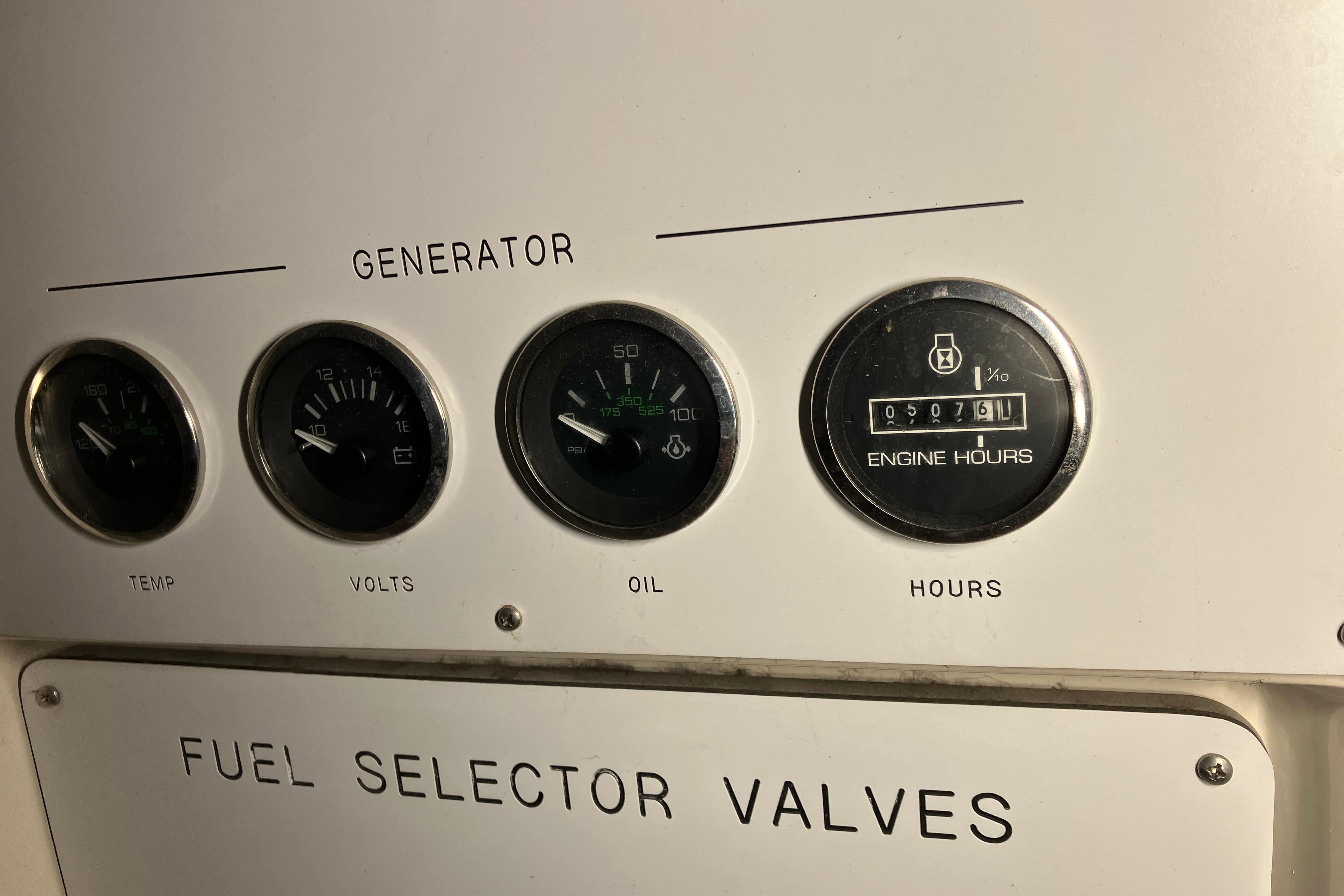Generator control panel of 2002 Sea Ray 410 Sundancer with gauges for temperature, volts, oil, and engine hours.