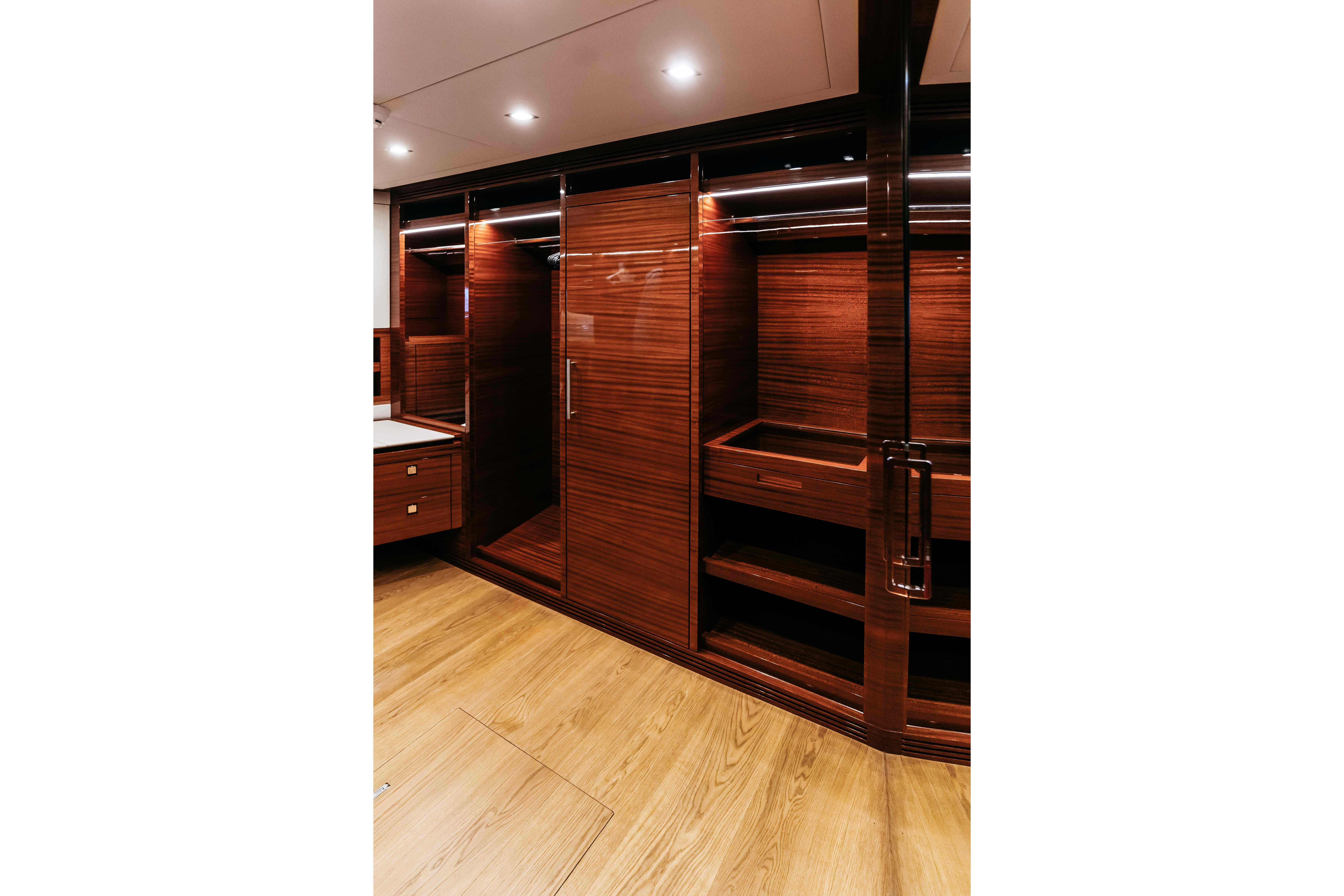Luxurious wooden interior of 2022 Bering 92 yacht with elegant cabinetry and lighting.