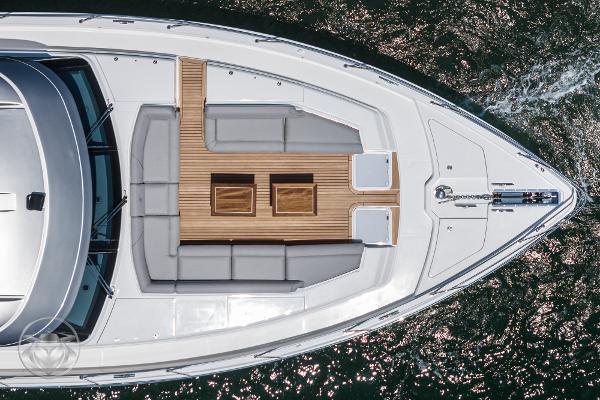 Aerial view of 2025 Riviera 645 SUV yacht's deck with seating and wooden flooring.
