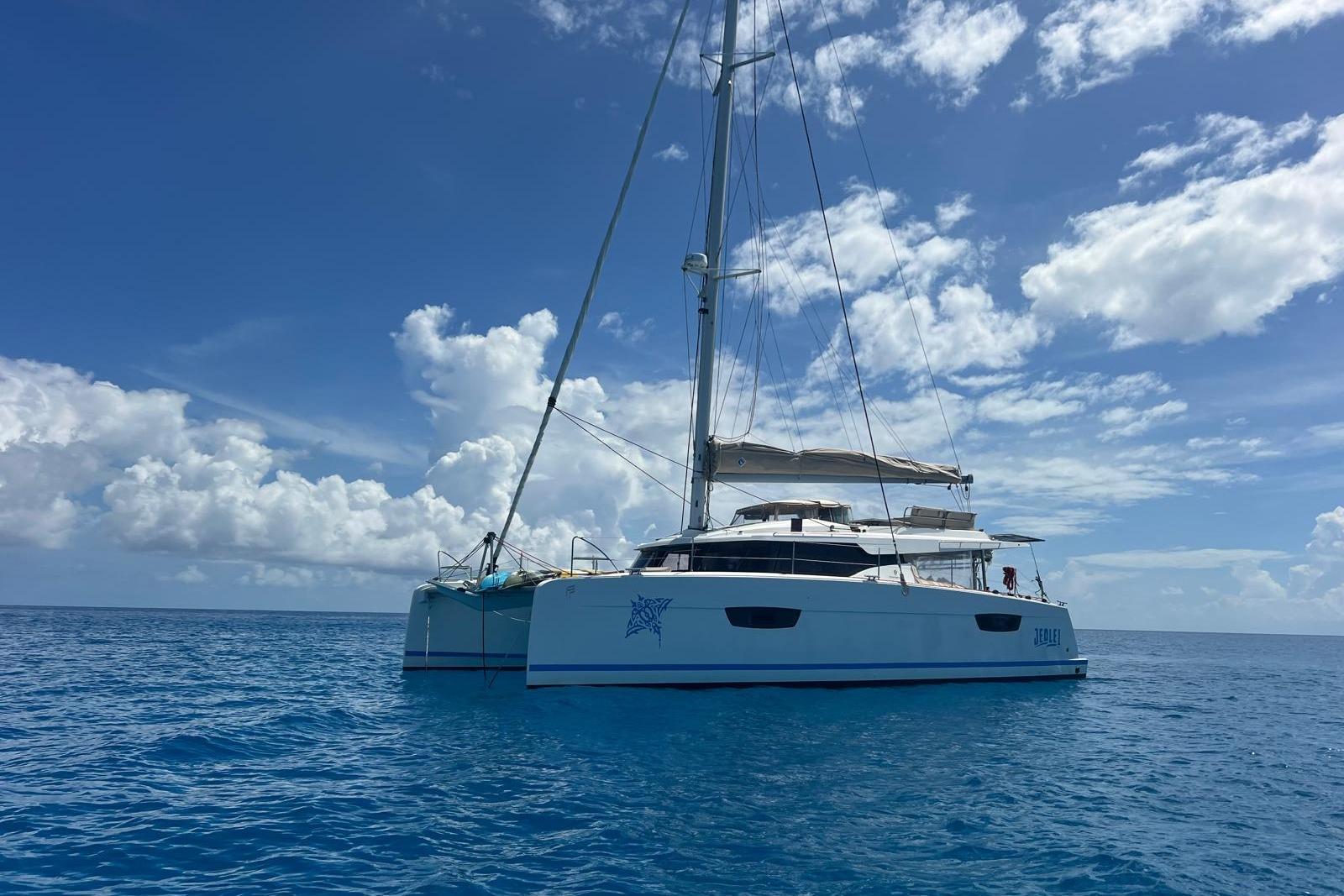 2022 Fountaine Pajot Elba 45 Catamaran sailing on clear blue ocean under a bright sky.
