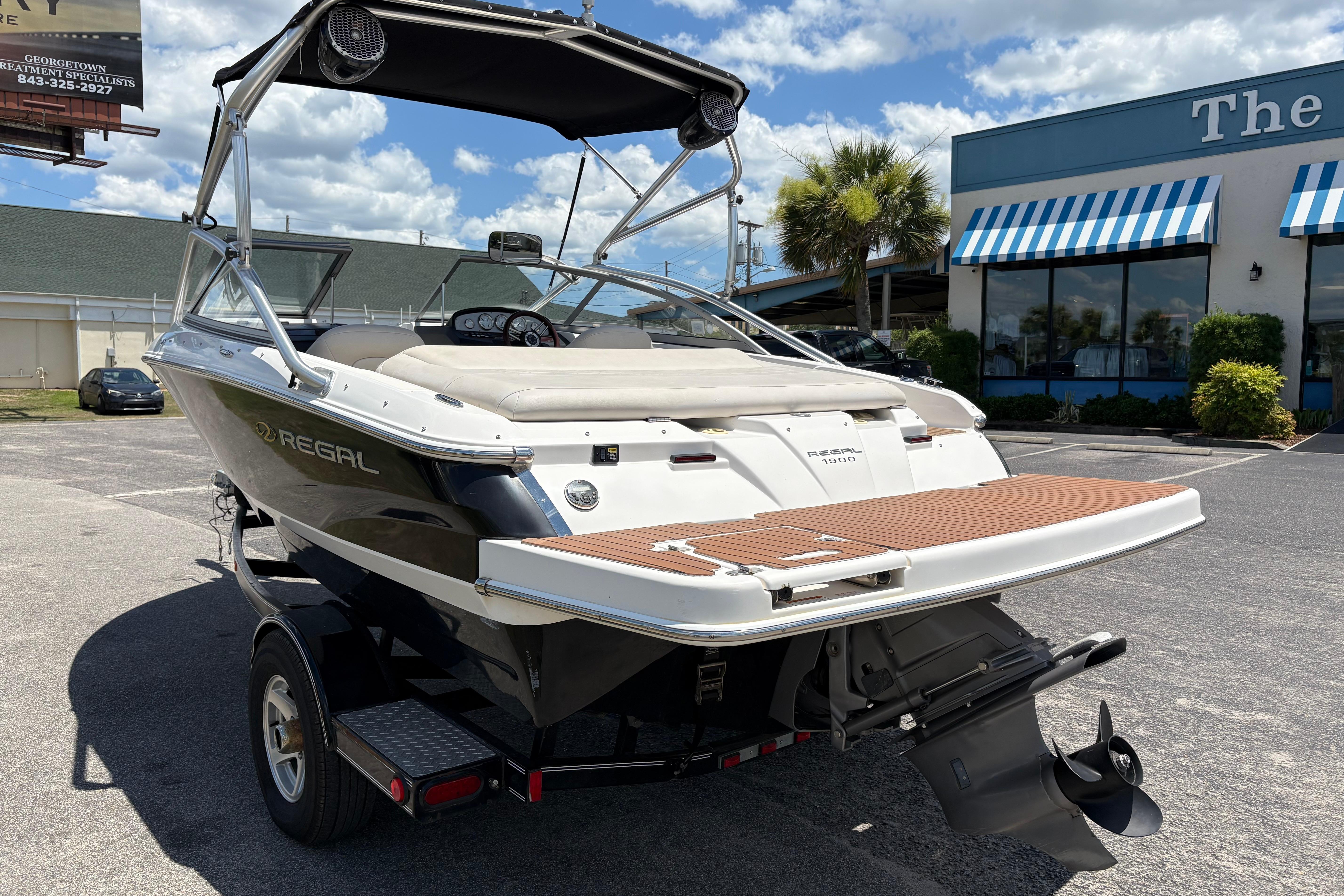 2008 Regal 1900 Bowrider boat in parking lot, rear view with trailer.