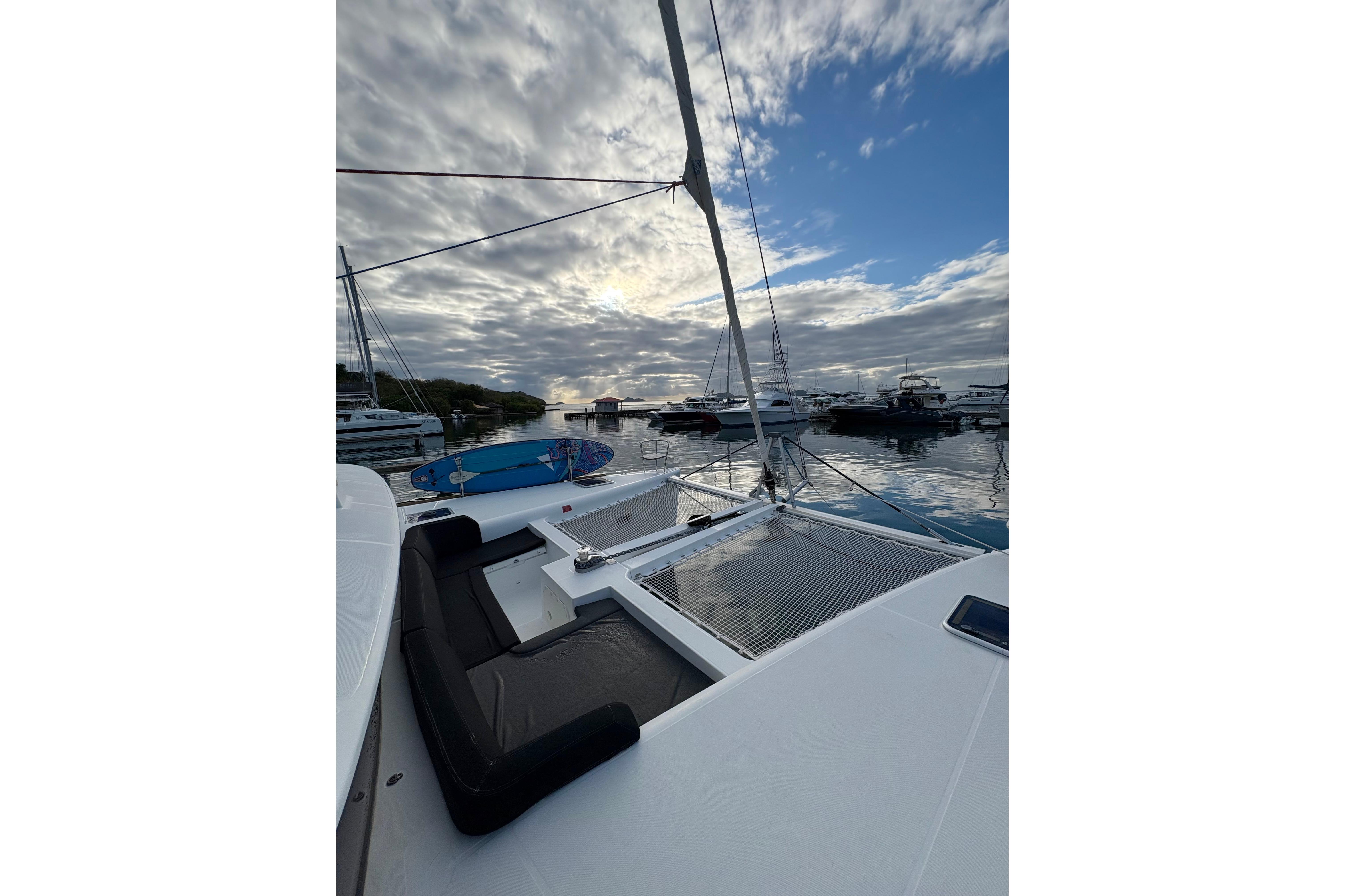 2018 Lagoon 450 catamaran docked at marina under cloudy sky.