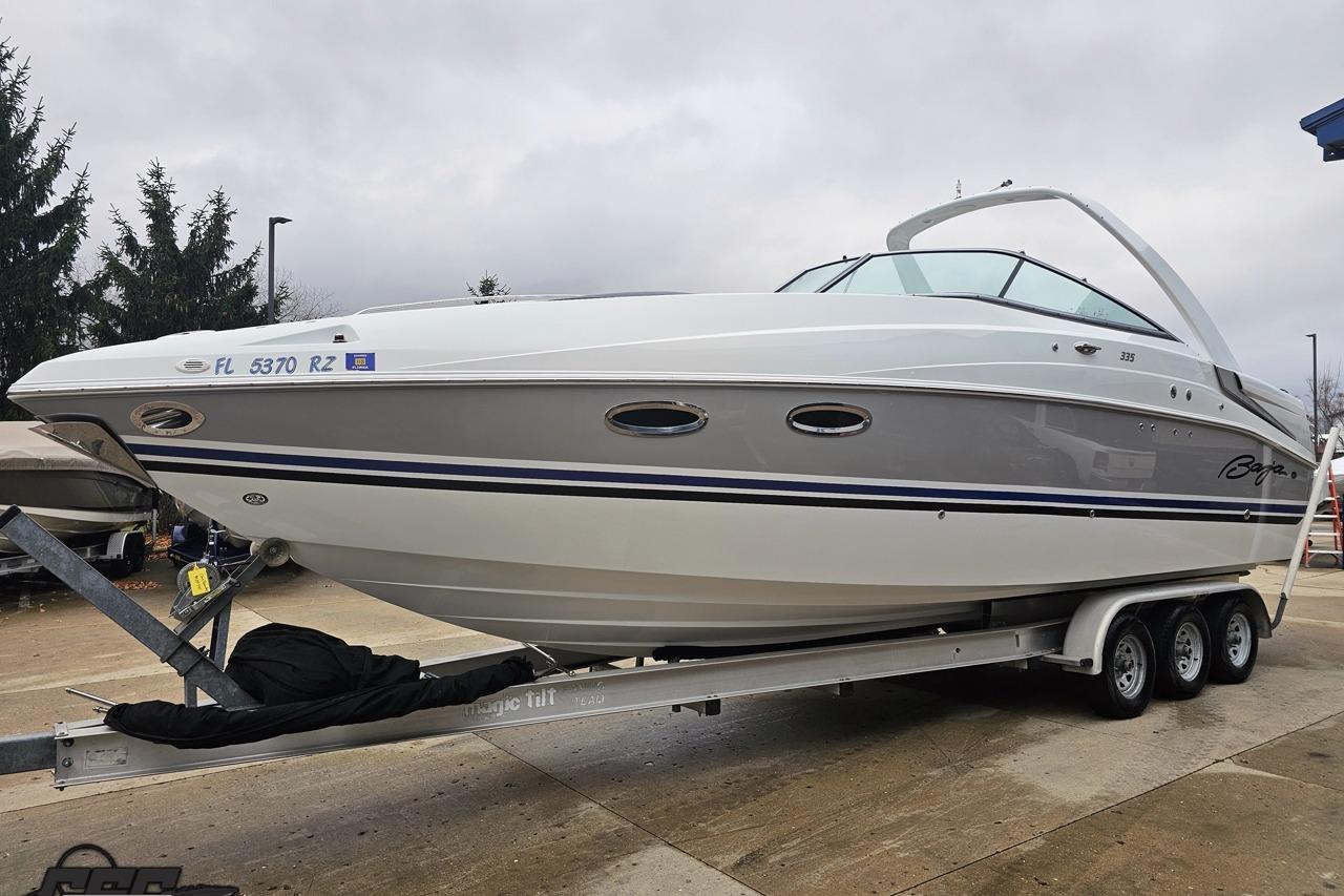 2008 Baja 335 Performance boat on trailer, white and gray design, parked outdoors.