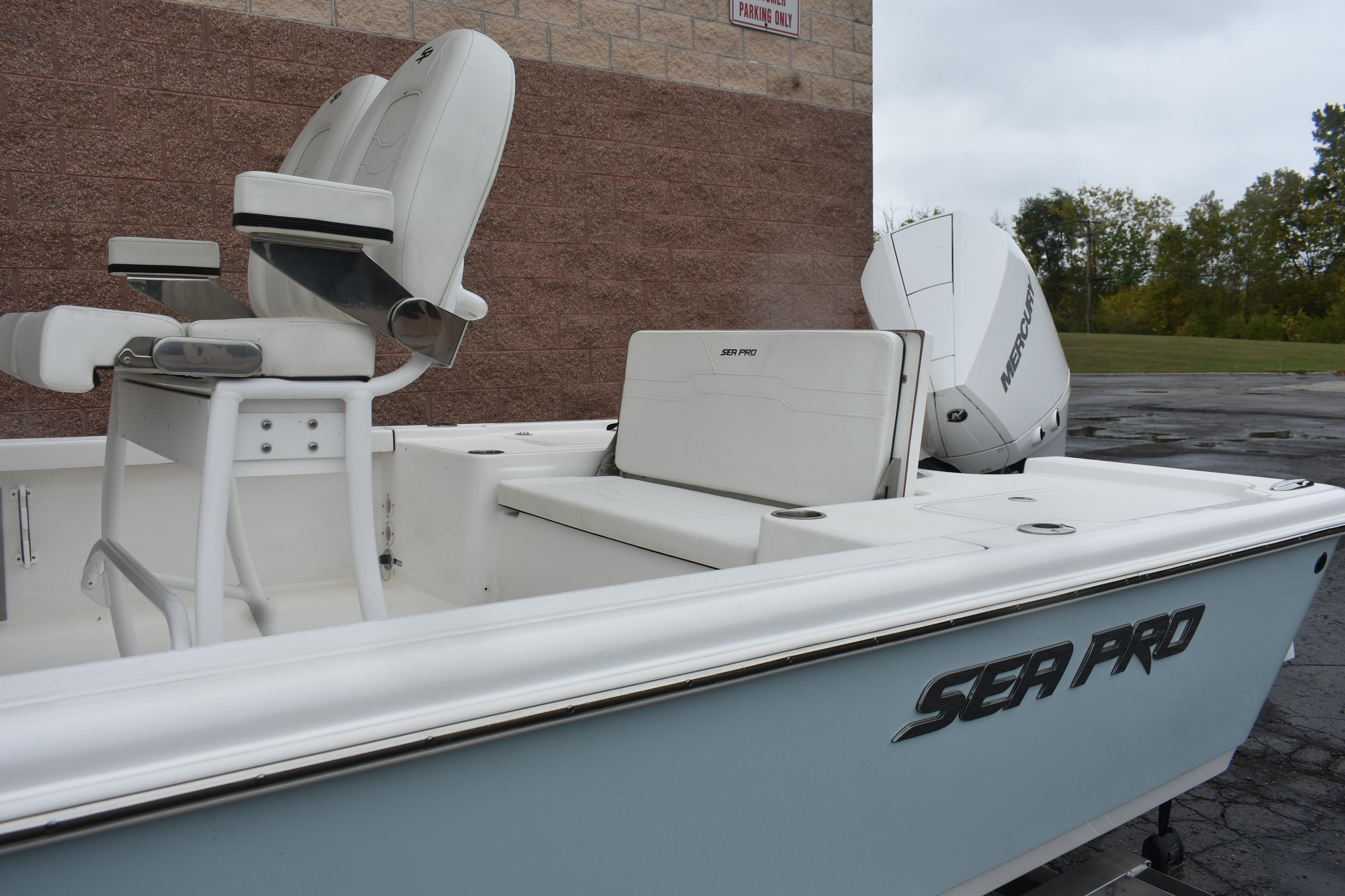 2025 Sea Pro 250 Bay boat with white seating and Mercury engine.