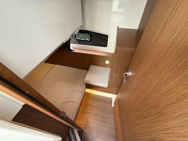 Interior of a 2021 Jeanneau NC 1095 with wooden walls and a bed.