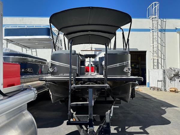 2025 Tahoe Pontoon 2585 LTZ Entertainer boat on trailer, outdoor display.