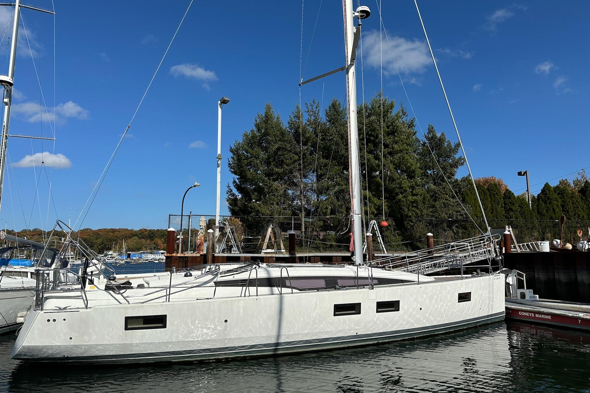 2018 Jeanneau 51 sailboat docked in a marina under a clear blue sky.