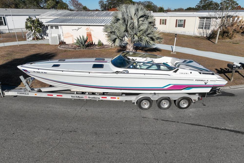1989 Formula 292 SR-1 boat on trailer, parked in residential area, side view.