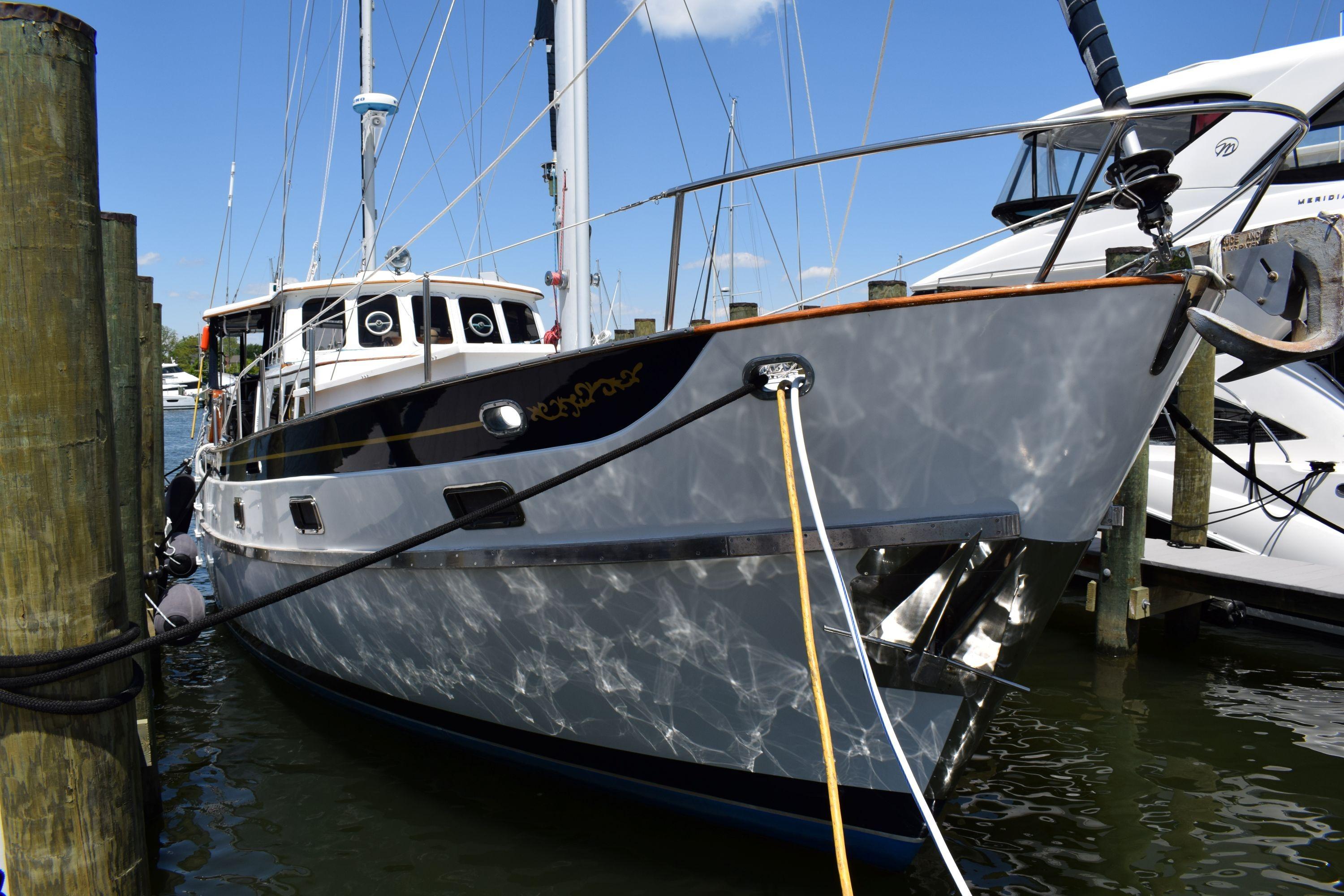 1980 Cheoy Lee 52 Motorsailer docked at marina under clear blue sky.